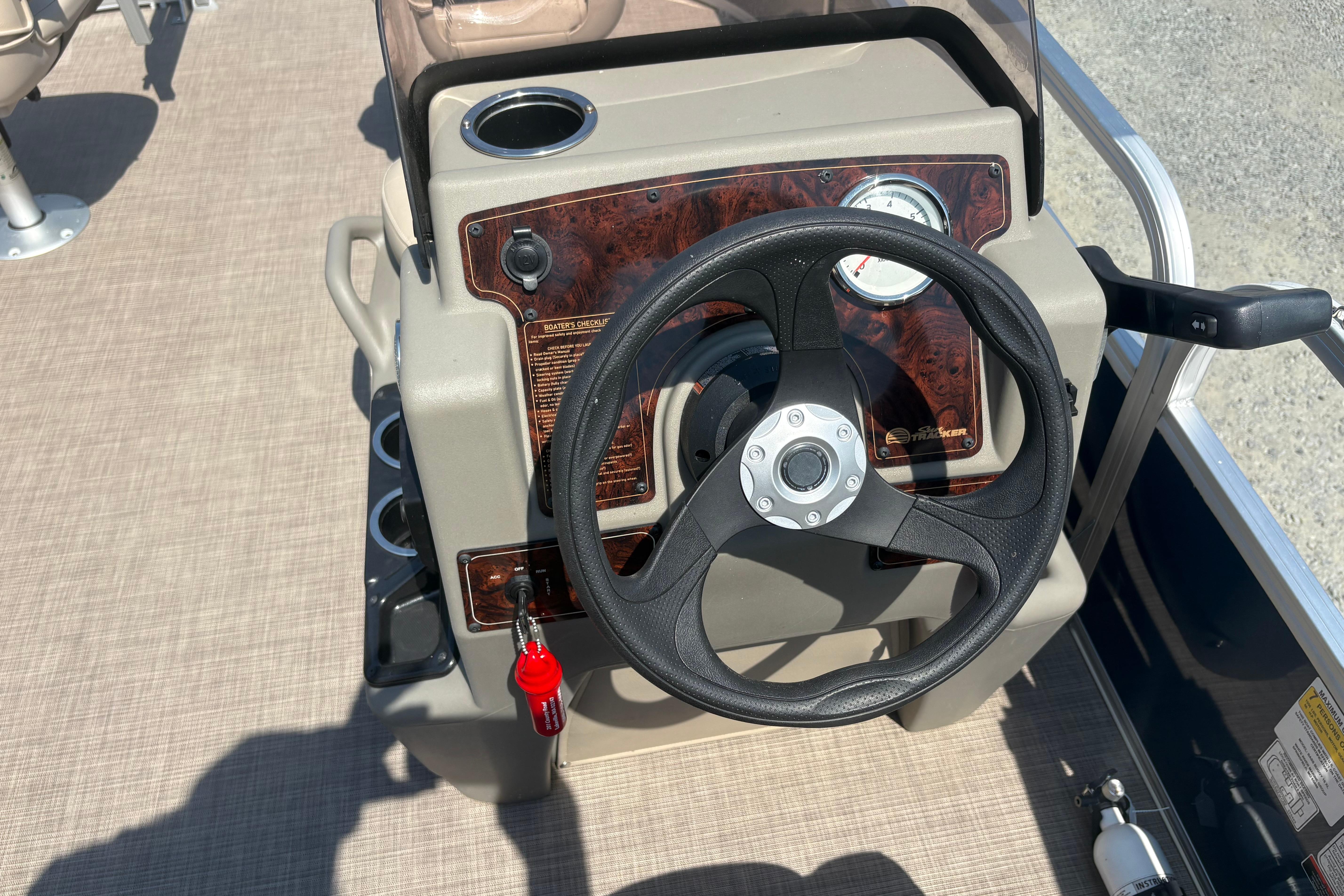 2024 Sun Tracker Bass Buggy 16 DLX steering console with black wheel and control panel.