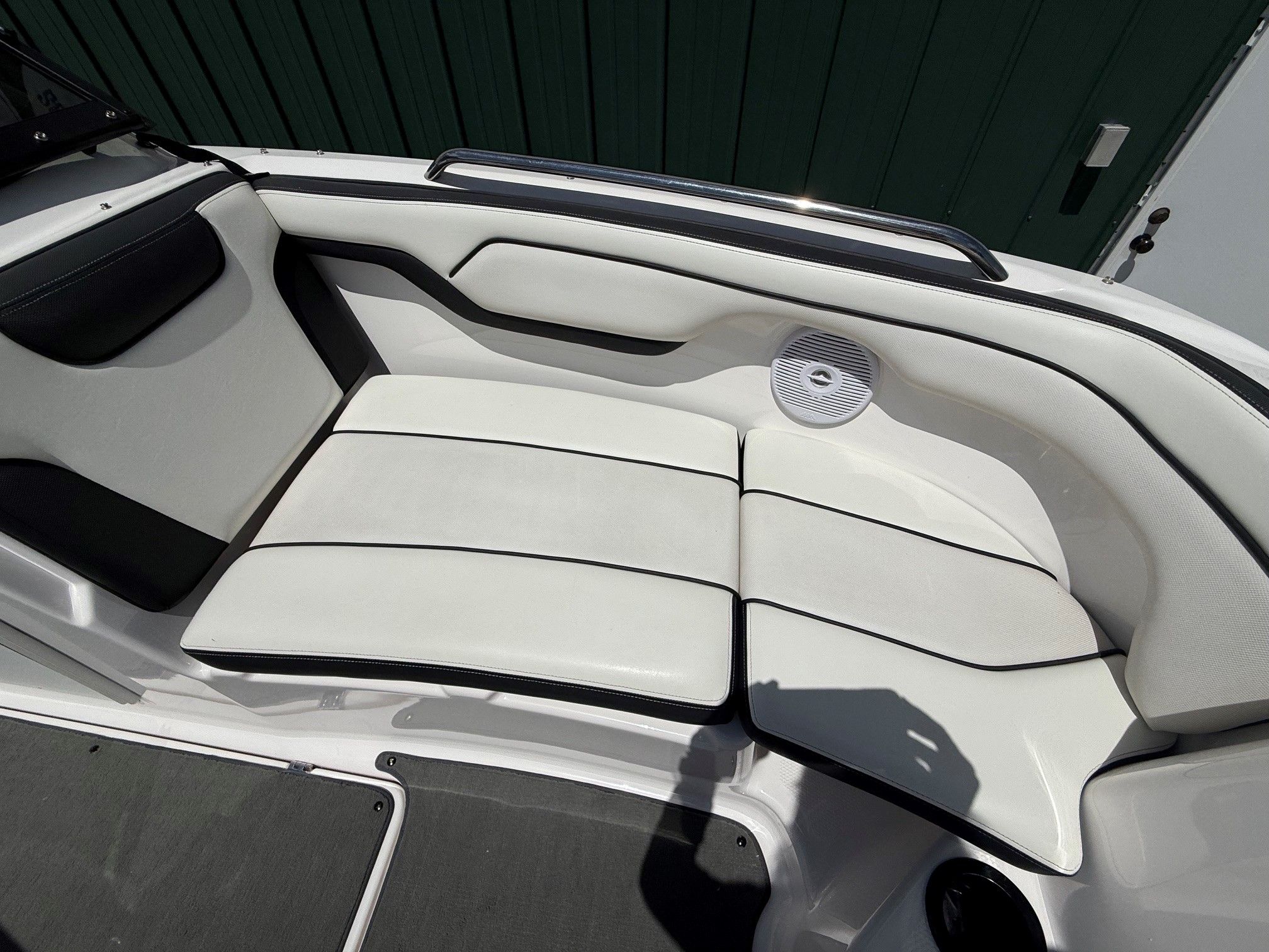 White seating area on a Yamaha SX210 boat with a speaker.