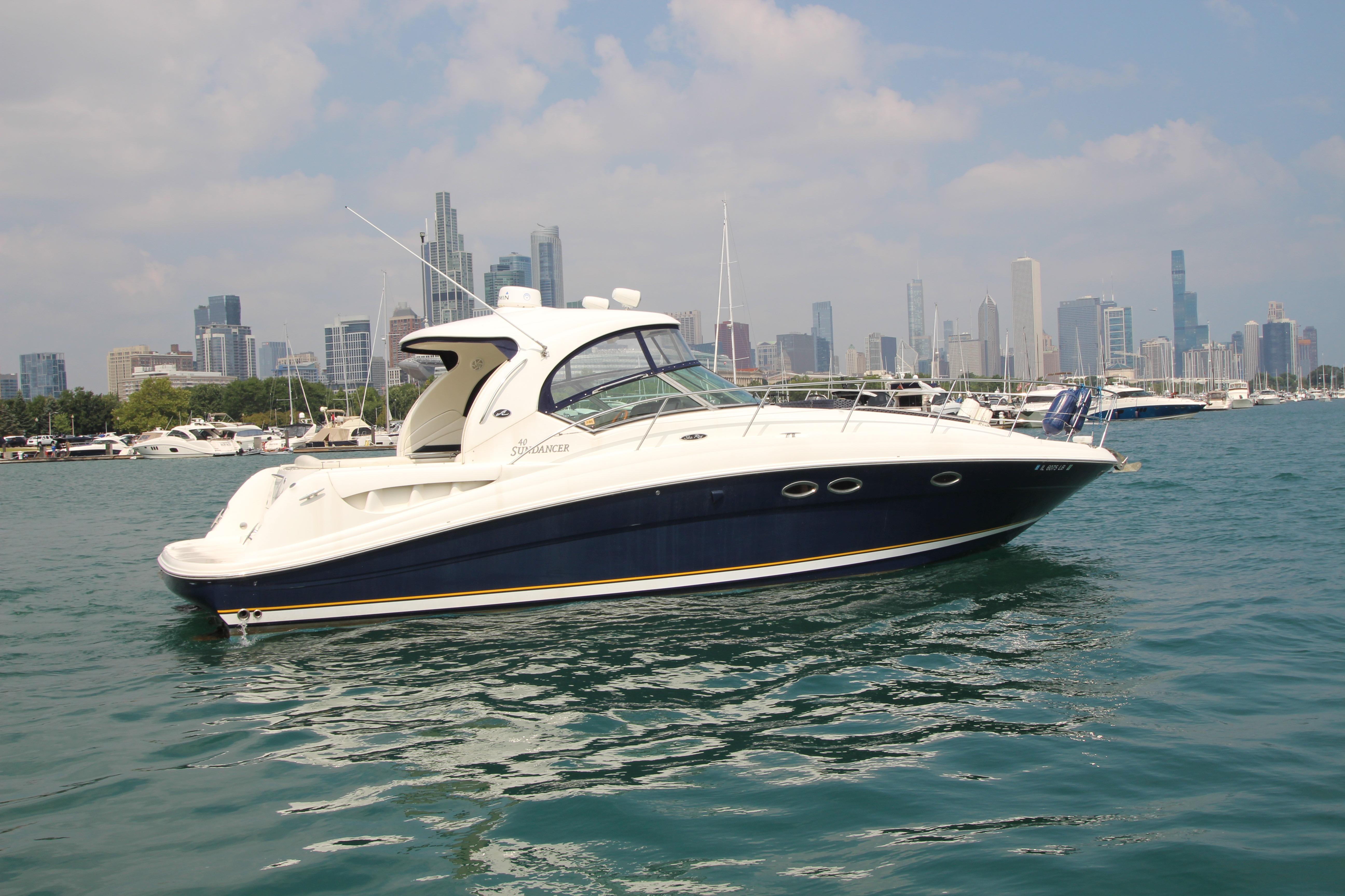 2004 Sea Ray 40 Sundancer yacht on water with city skyline in background.