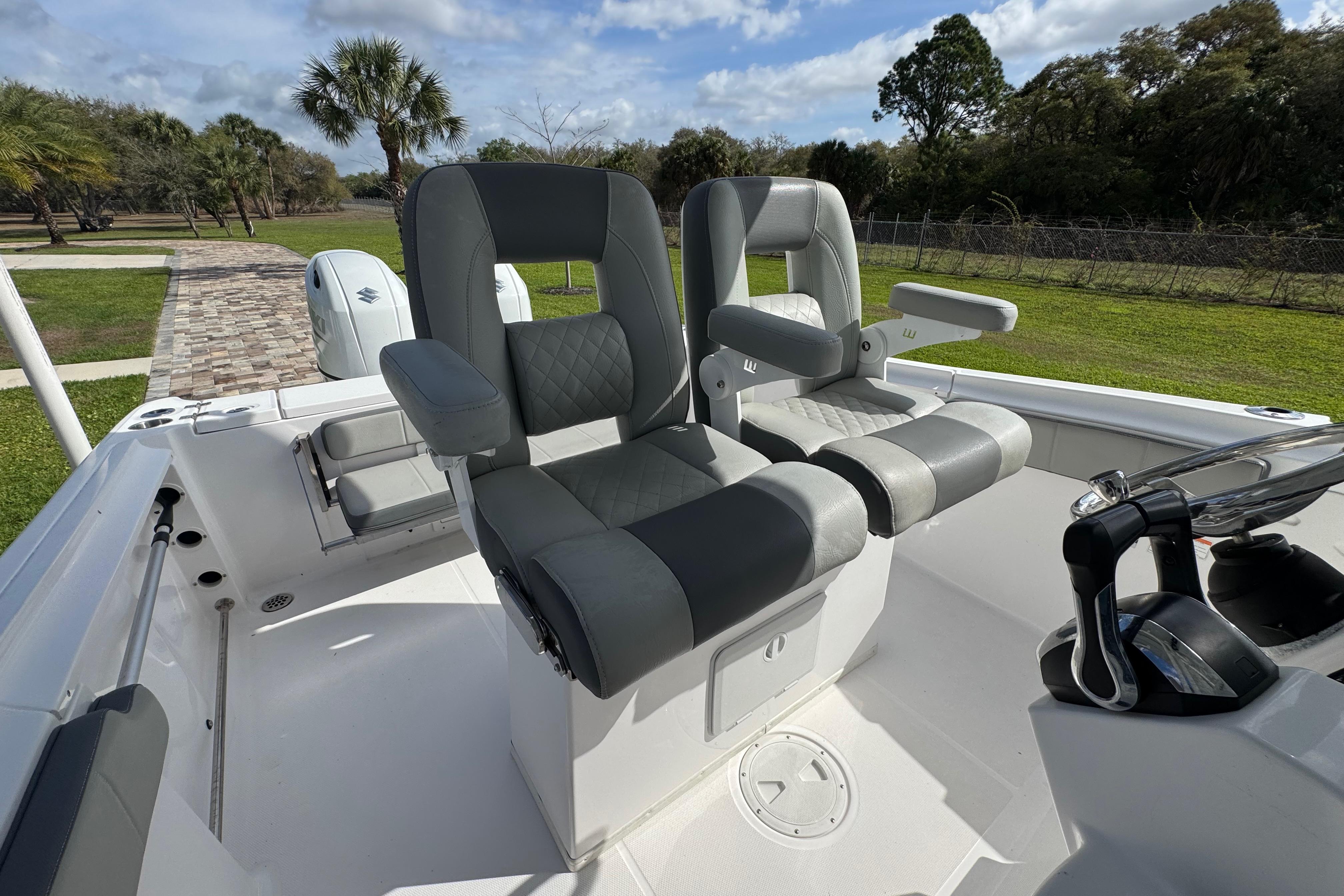 2022 Aquasport 2500 Center Console boat with dual seating and lush green surroundings.