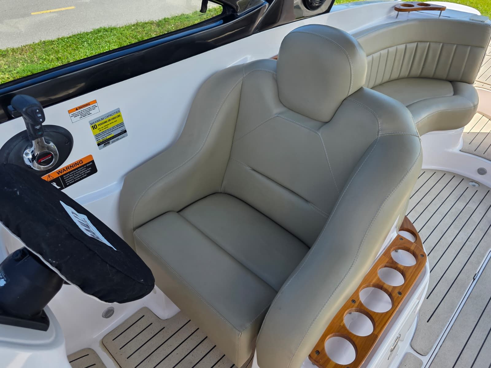 Interior of the Coral 26 boat with beige seating and steering wheel.