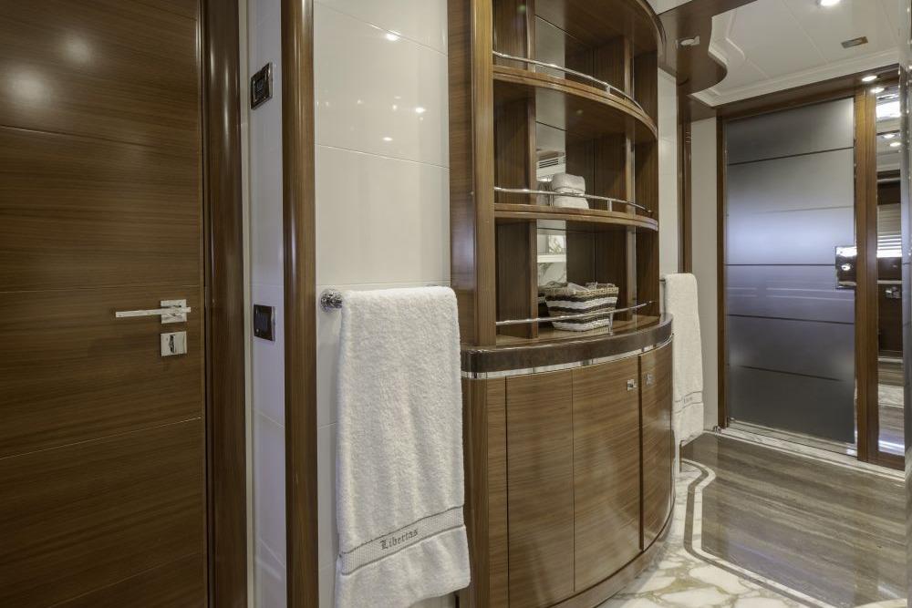 Luxurious yacht interior with wooden cabinetry, marble flooring, and elegant towel arrangement, CRN 129, 2009.