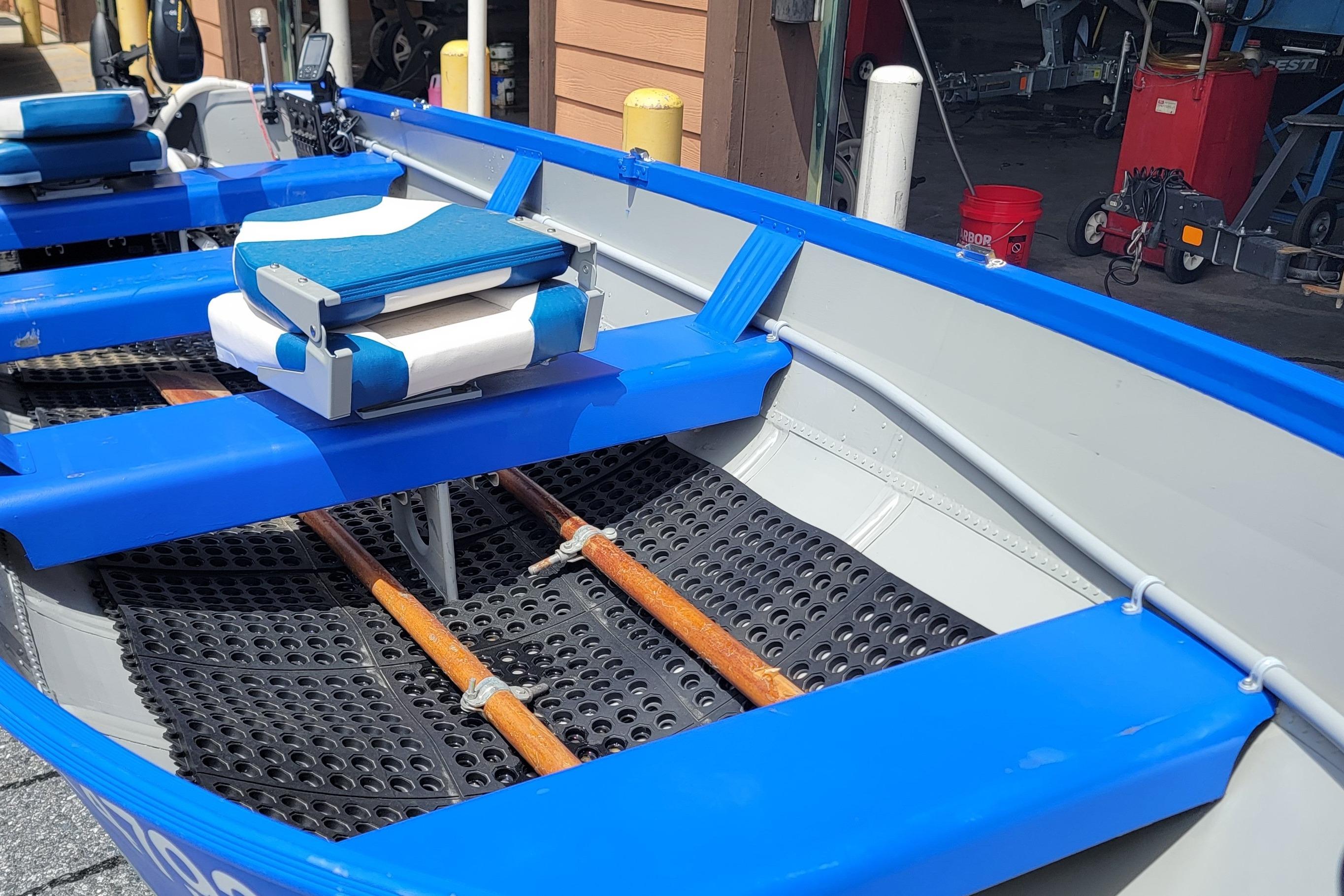 1966 Sea Nymph V-14 boat interior with blue seats and wooden oars.