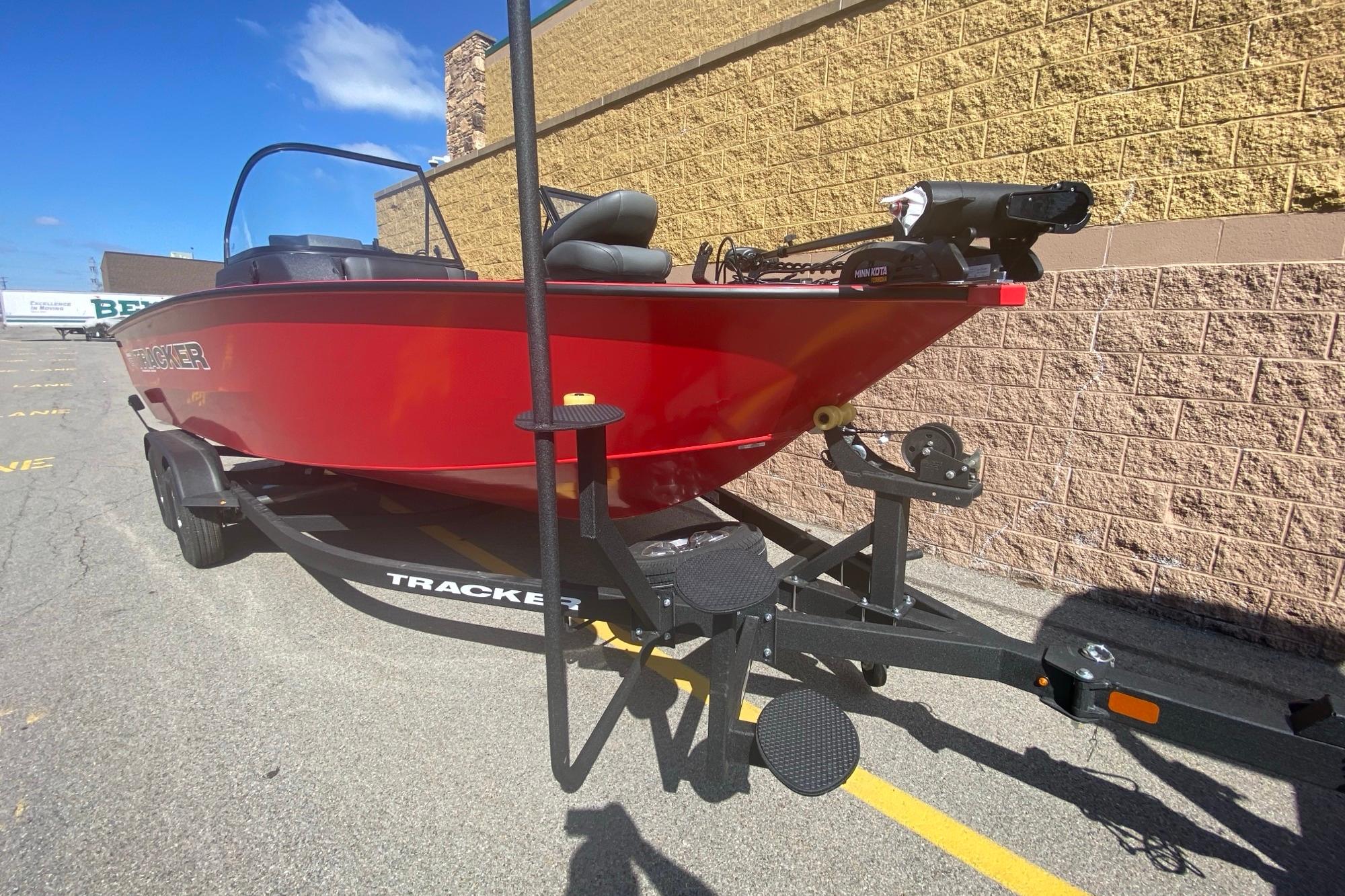 2026 Tracker Targa V-18 WT boat in vibrant red on a trailer, parked outdoors.