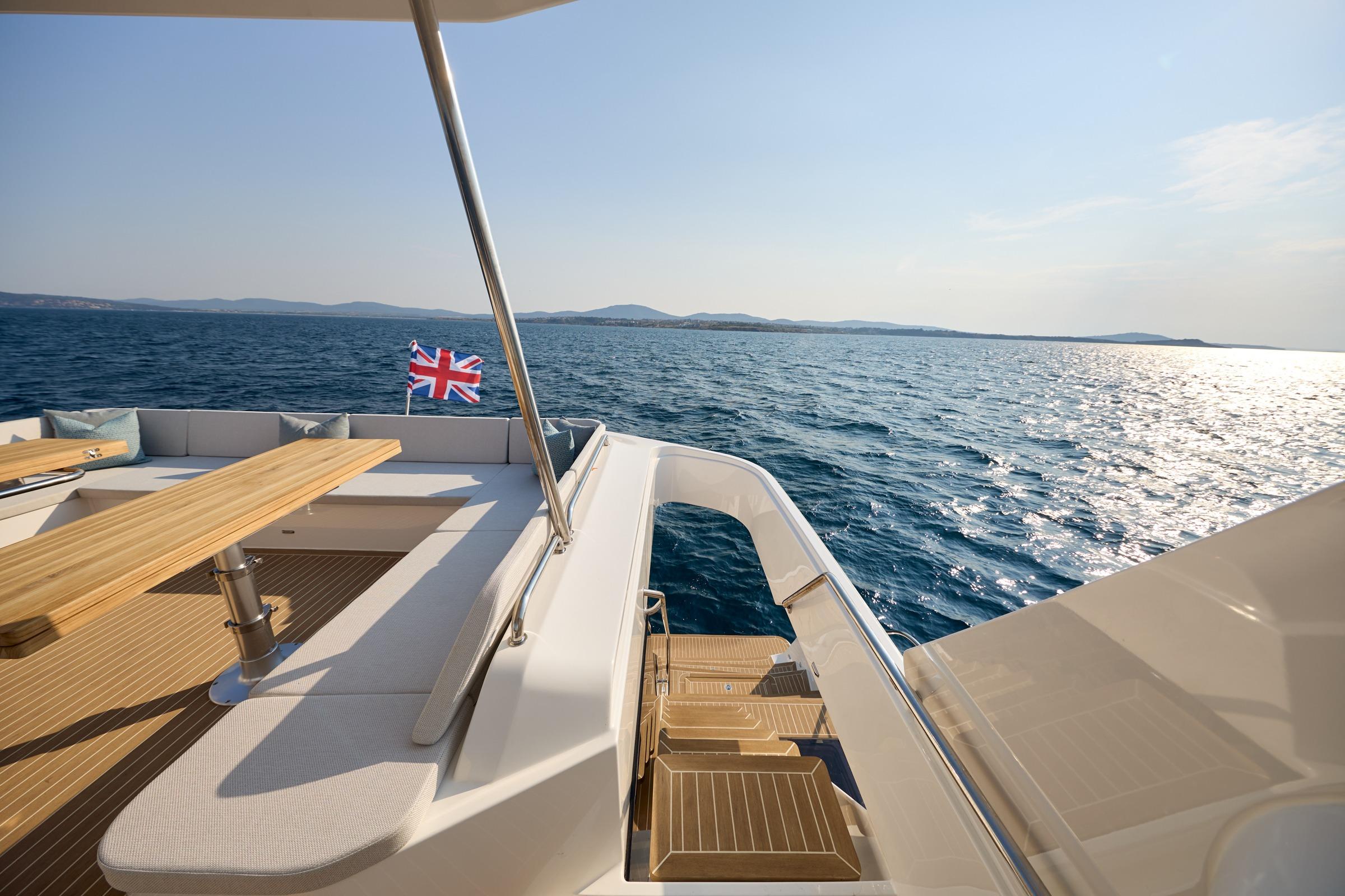 2025 Custom Omaya 50 Power Catamaran deck with ocean view and British flag.