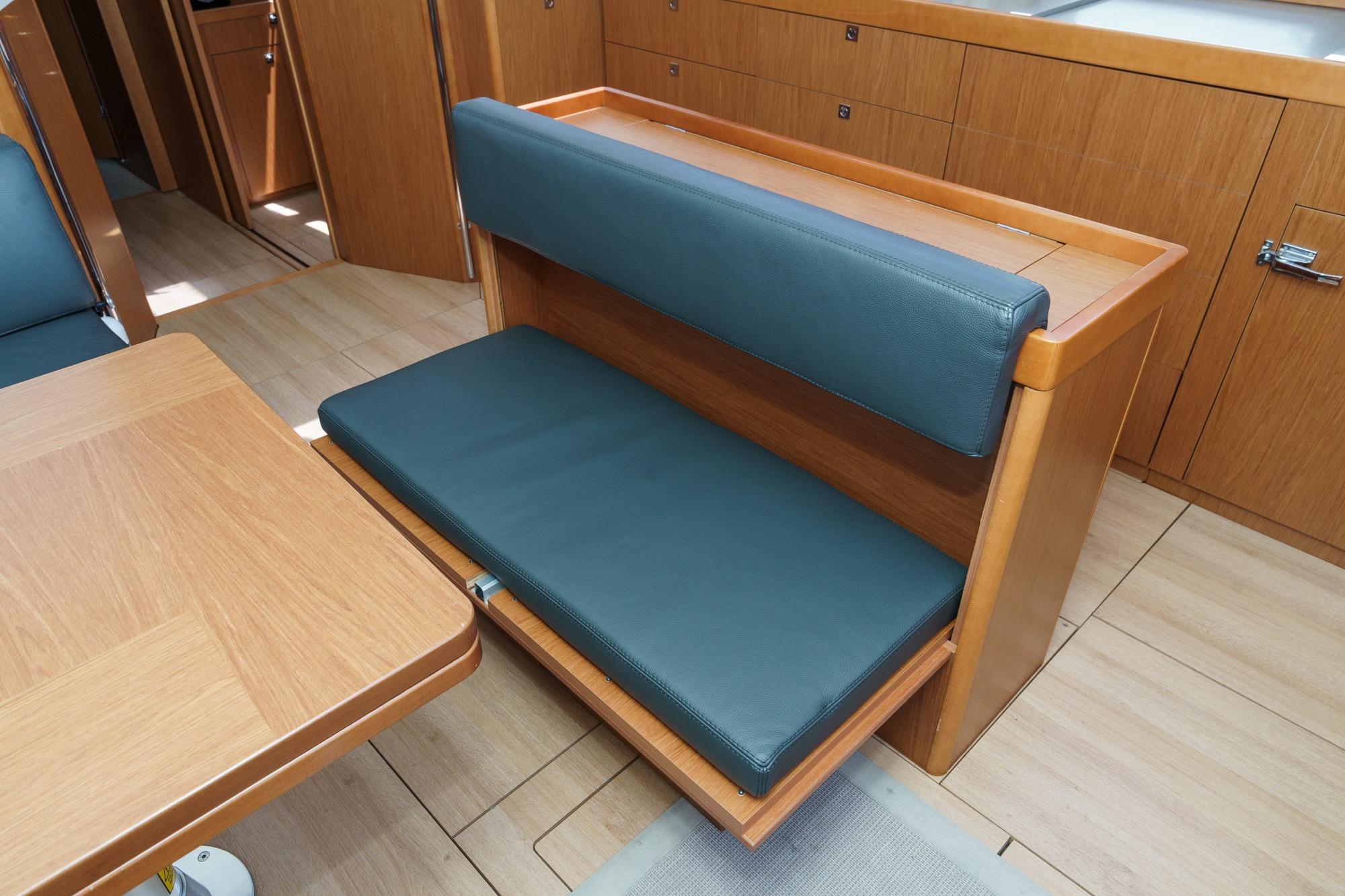 Interior of 2017 Beneteau Sense 50 yacht with wooden cabinetry and cushioned seating.