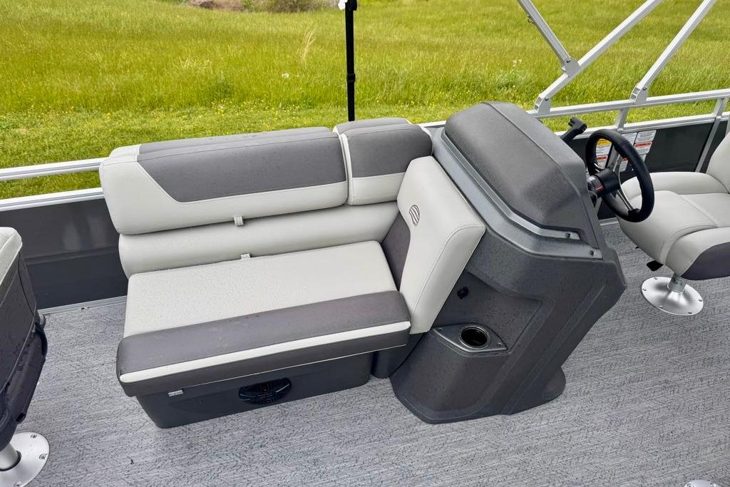 2026 Sun Tracker Fishin' Barge 20 DLX interior with gray seating and steering console.