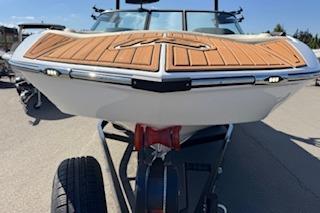 2026 MB B52-23 Classic LIMITED boat with wooden deck, on trailer, sunny day.