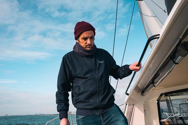 Man on Nautitech 40 Open yacht, 2025 model, sailing under clear skies.
