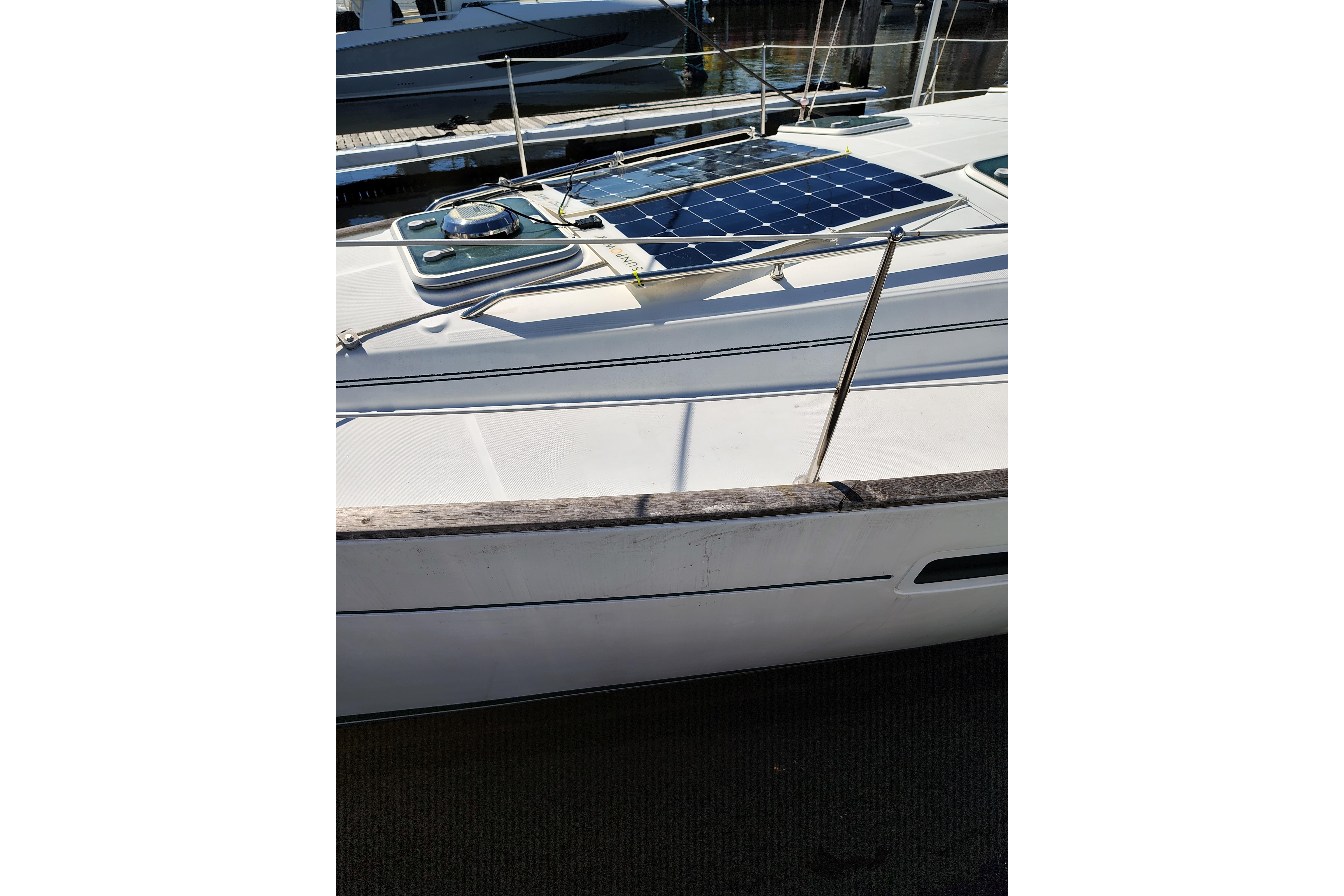 2001 Beneteau Oceanis 411 sailboat with solar panel on deck, docked at marina.