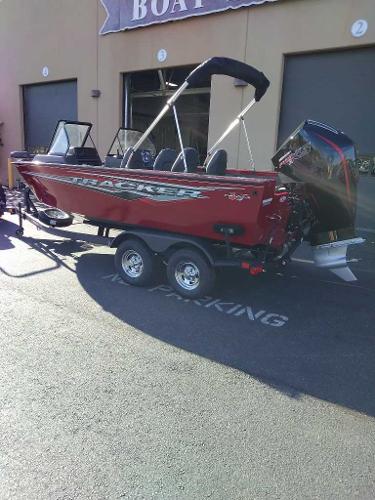 2024 Tracker Targa V-19 WT boat in red, parked outside a building.