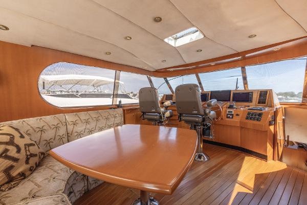 Luxurious interior of 2001 Grand Harbour 76 yacht with wooden furnishings and modern helm.