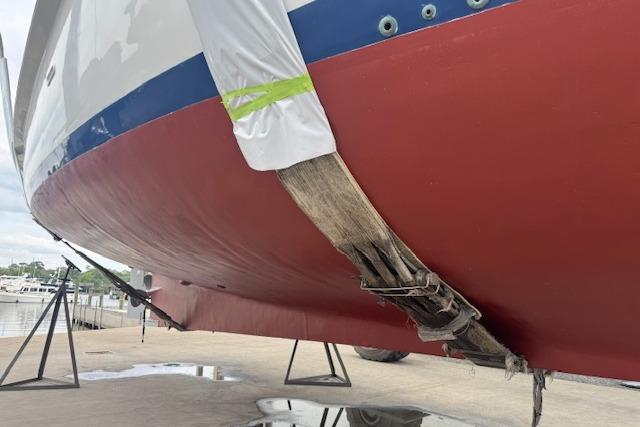 1986 Krogen 42 Classic boat hull on dry dock, showing red and white paint.