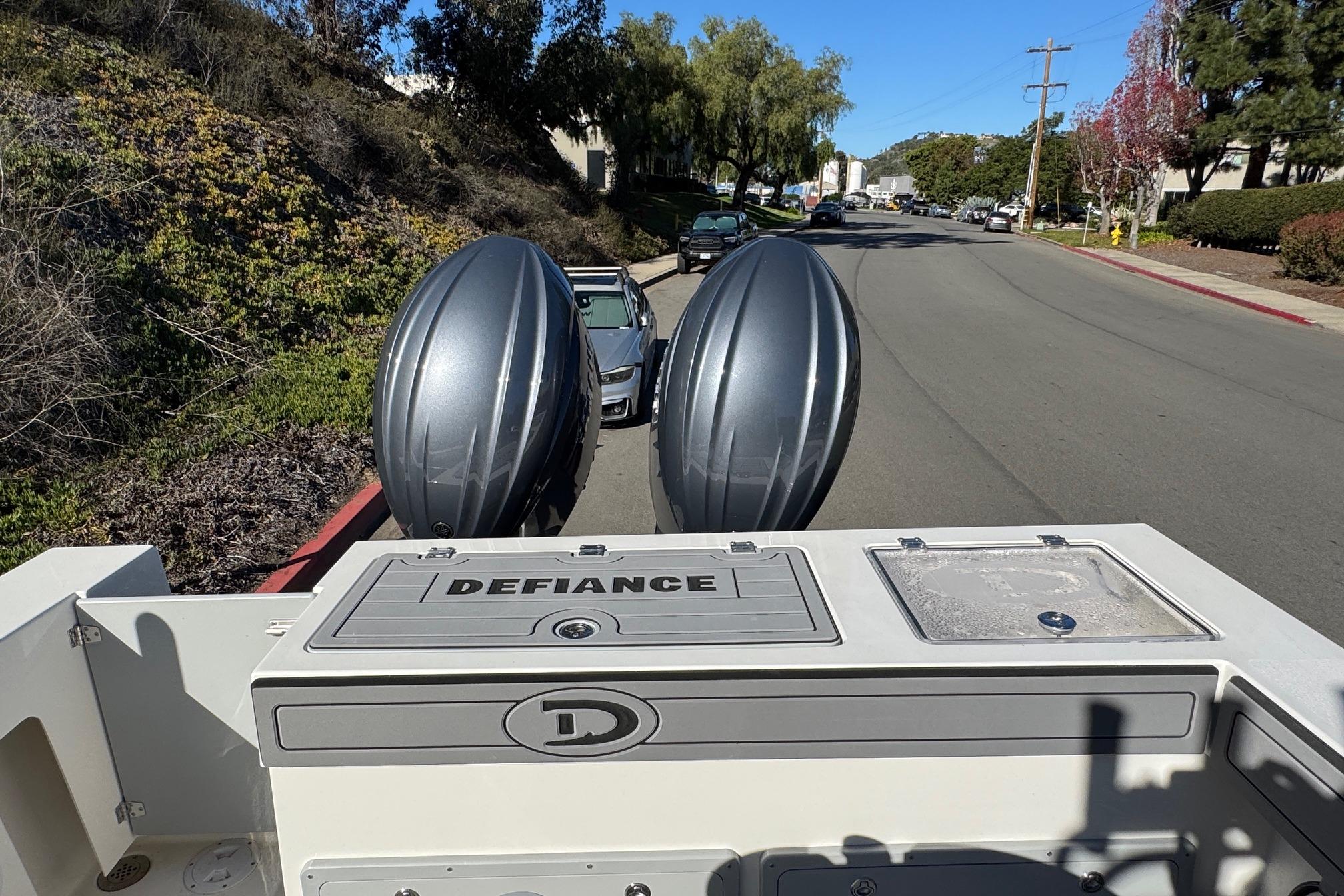 2026 Defiance Admiral 250 EX boat with dual engines on a street.