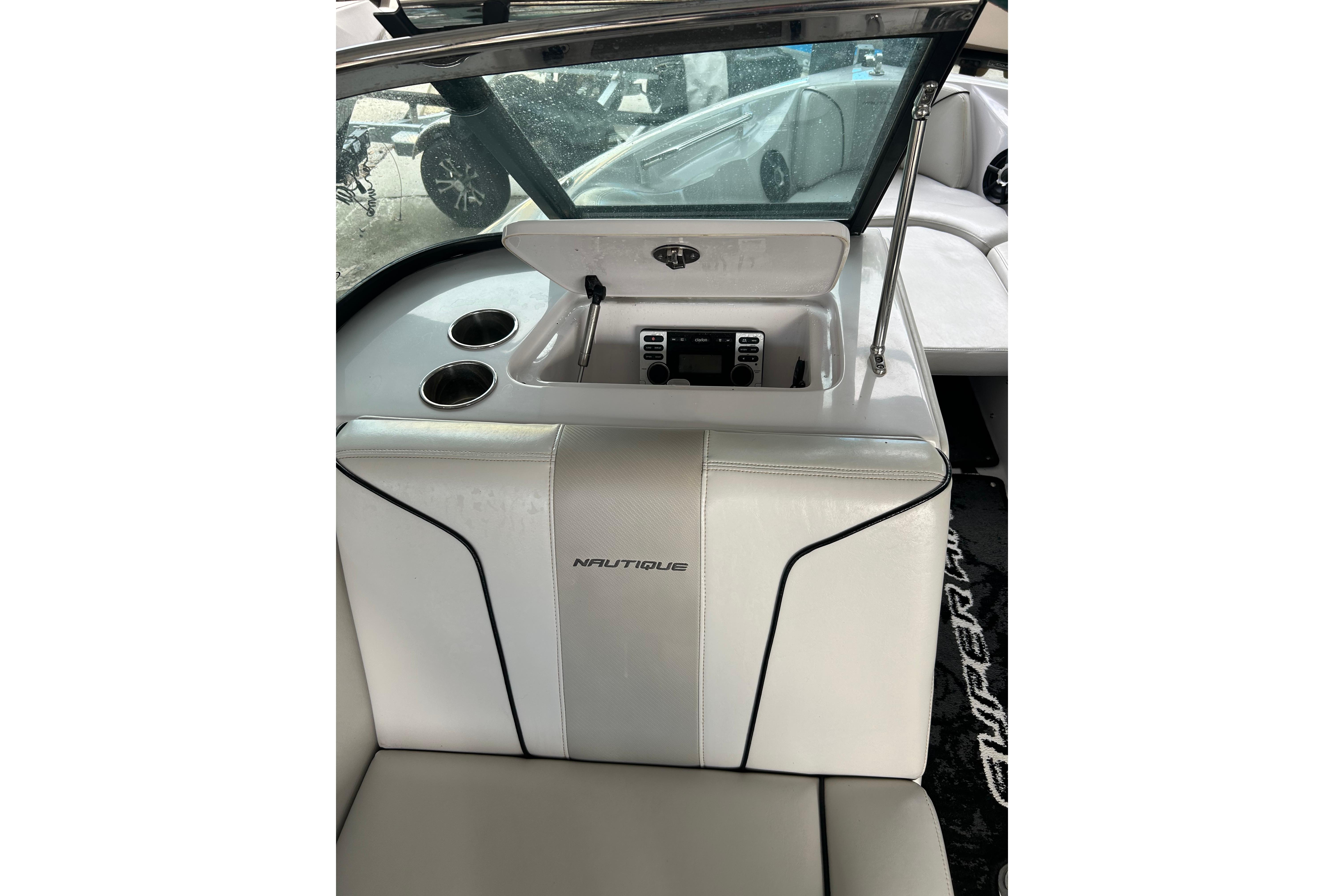 Interior of 2010 Nautique Super Air Nautique 210 Coastal Edition boat, featuring cup holders and storage.