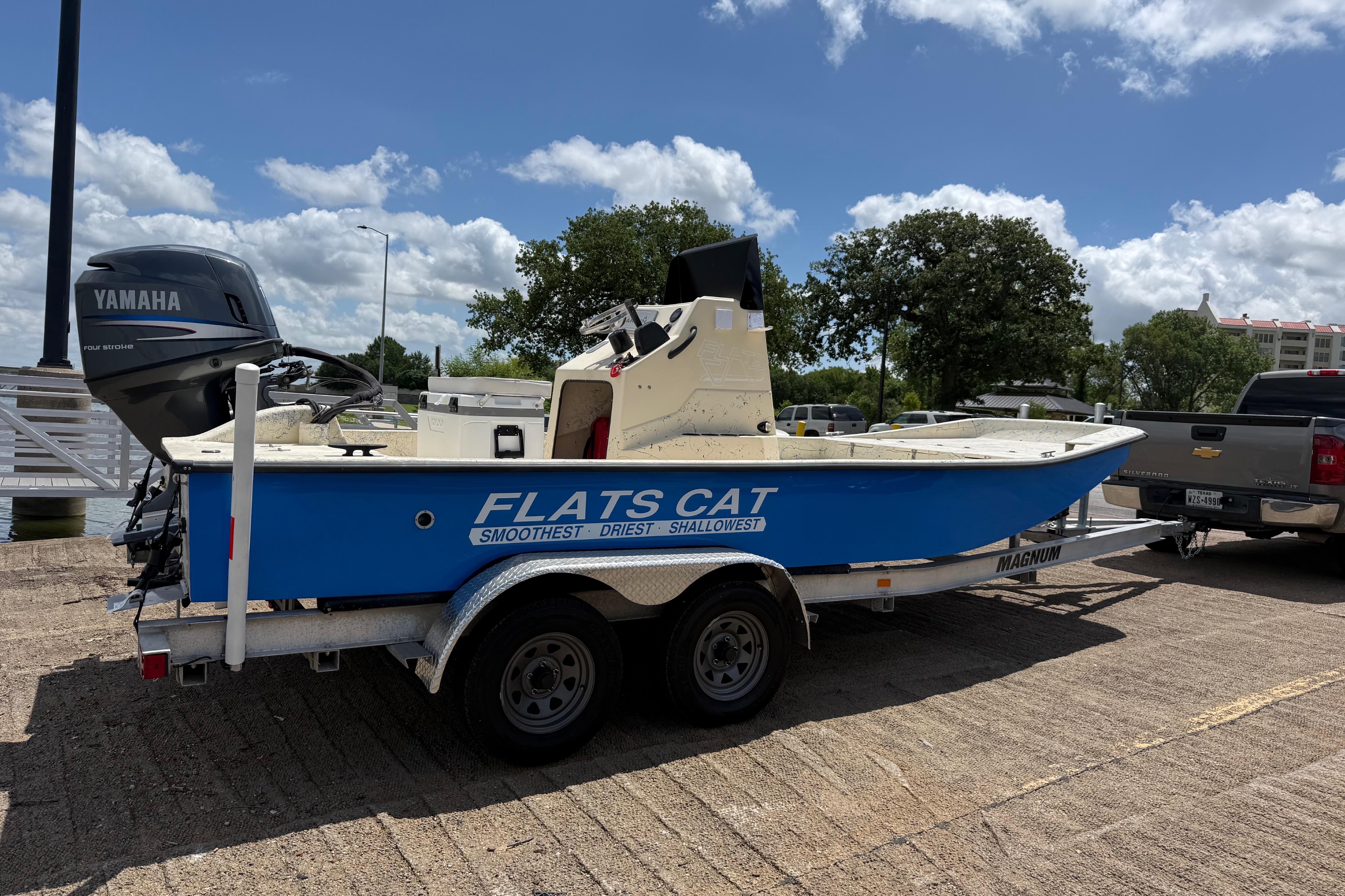 2007 Flats Cat 19 boat on trailer with Yamaha engine, parked outdoors under a blue sky.