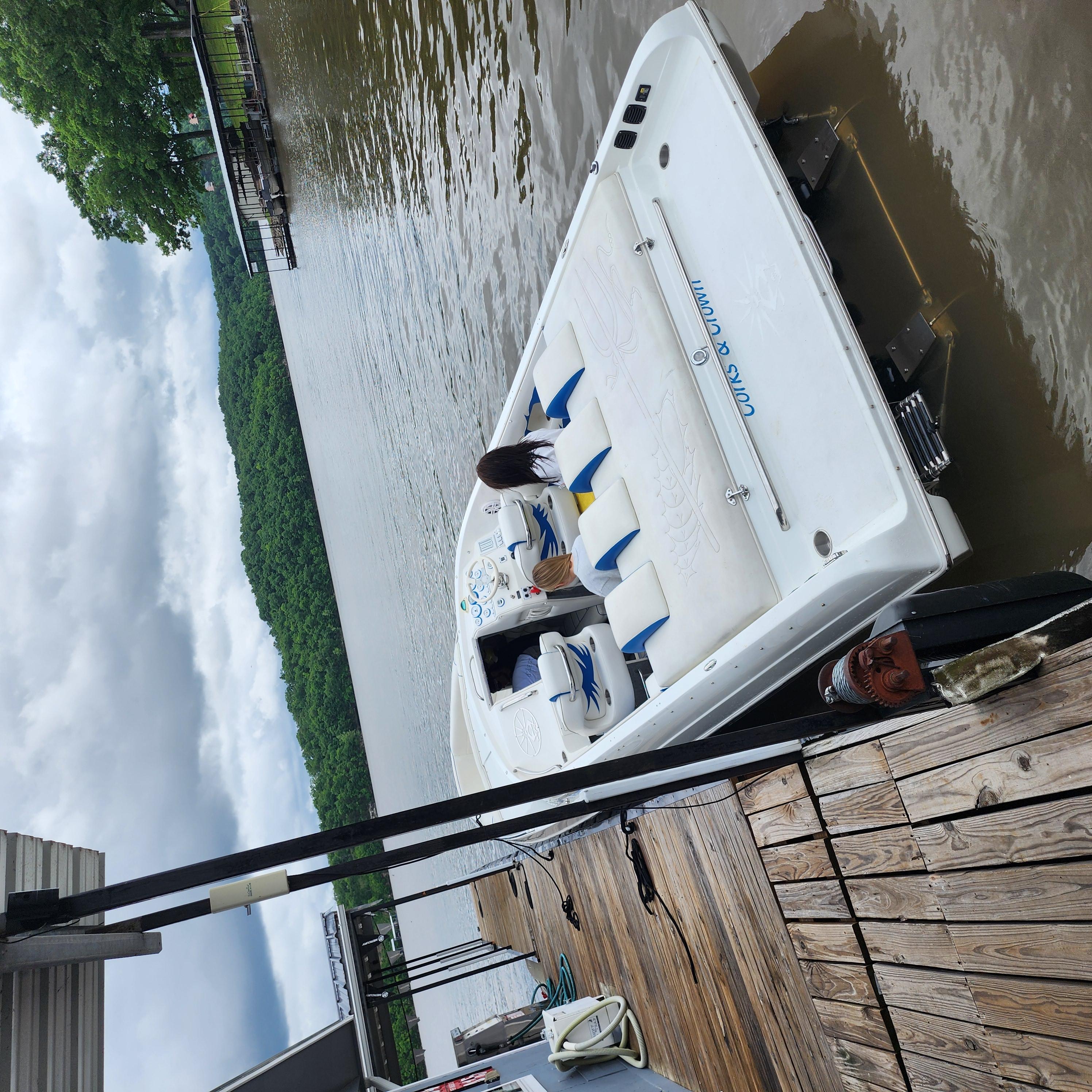 2005 Kachina Bolero boat docked on a lake with lush green surroundings.