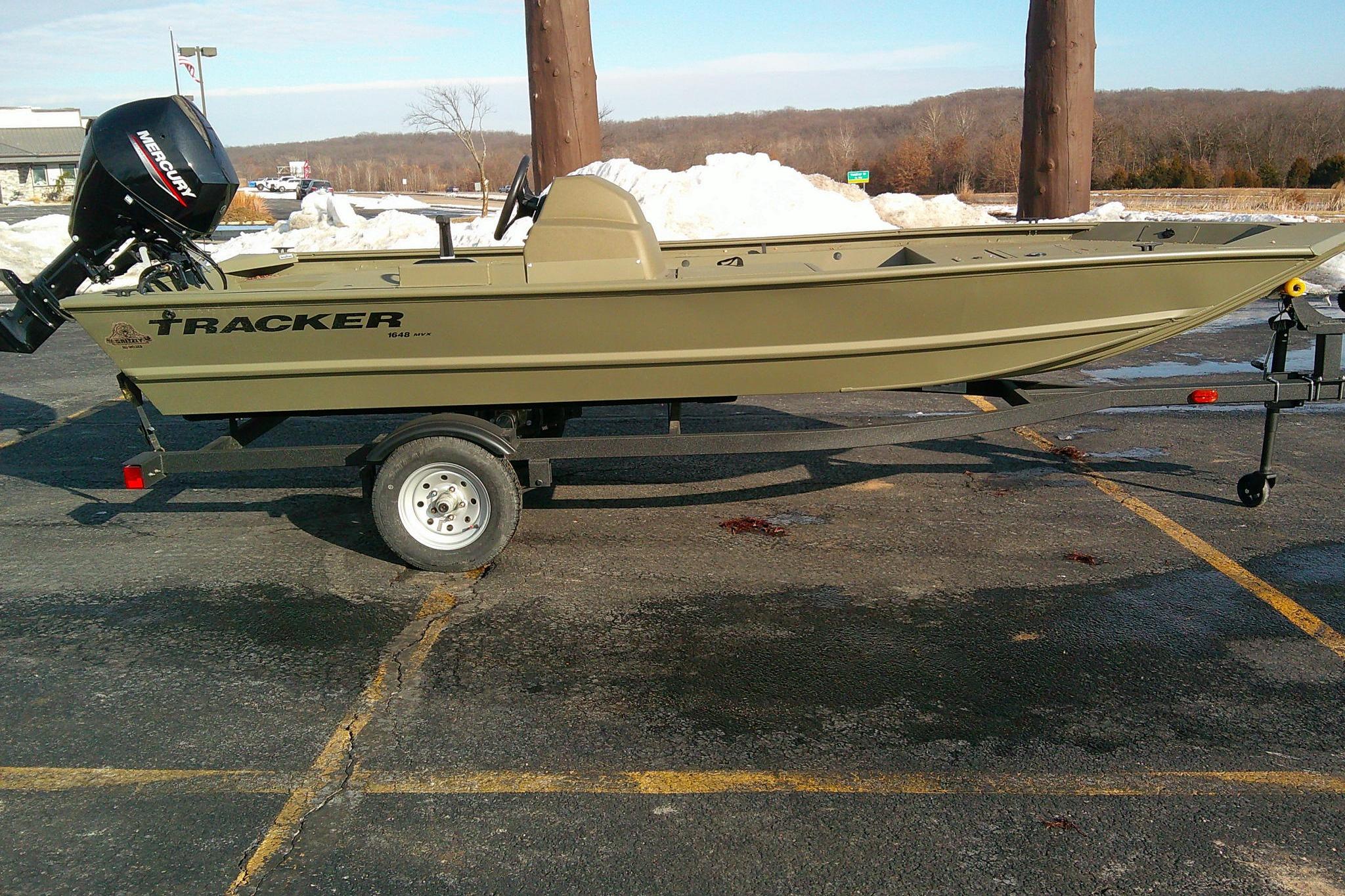 2025 Tracker Grizzly 1648 SC boat on trailer in parking lot.
