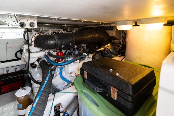 Engine room of a 1999 Viking 47 Convertible yacht, featuring mechanical components and storage.
