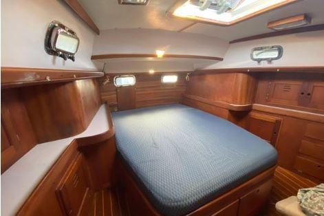 1997 Freedom 45 yacht interior with wooden finish and cozy bed.