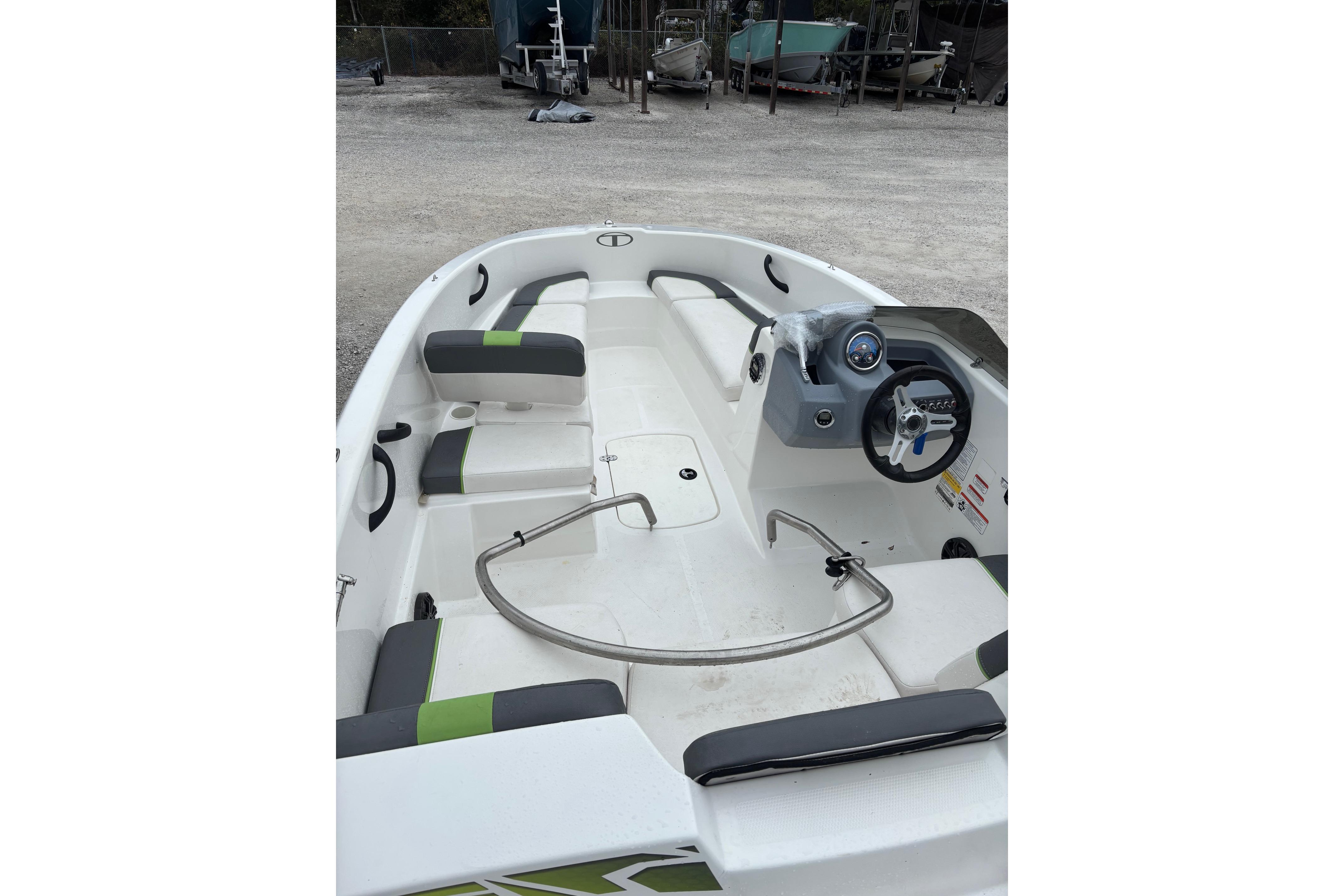 2022 Tahoe T16 boat interior with seating and steering wheel, parked on gravel.