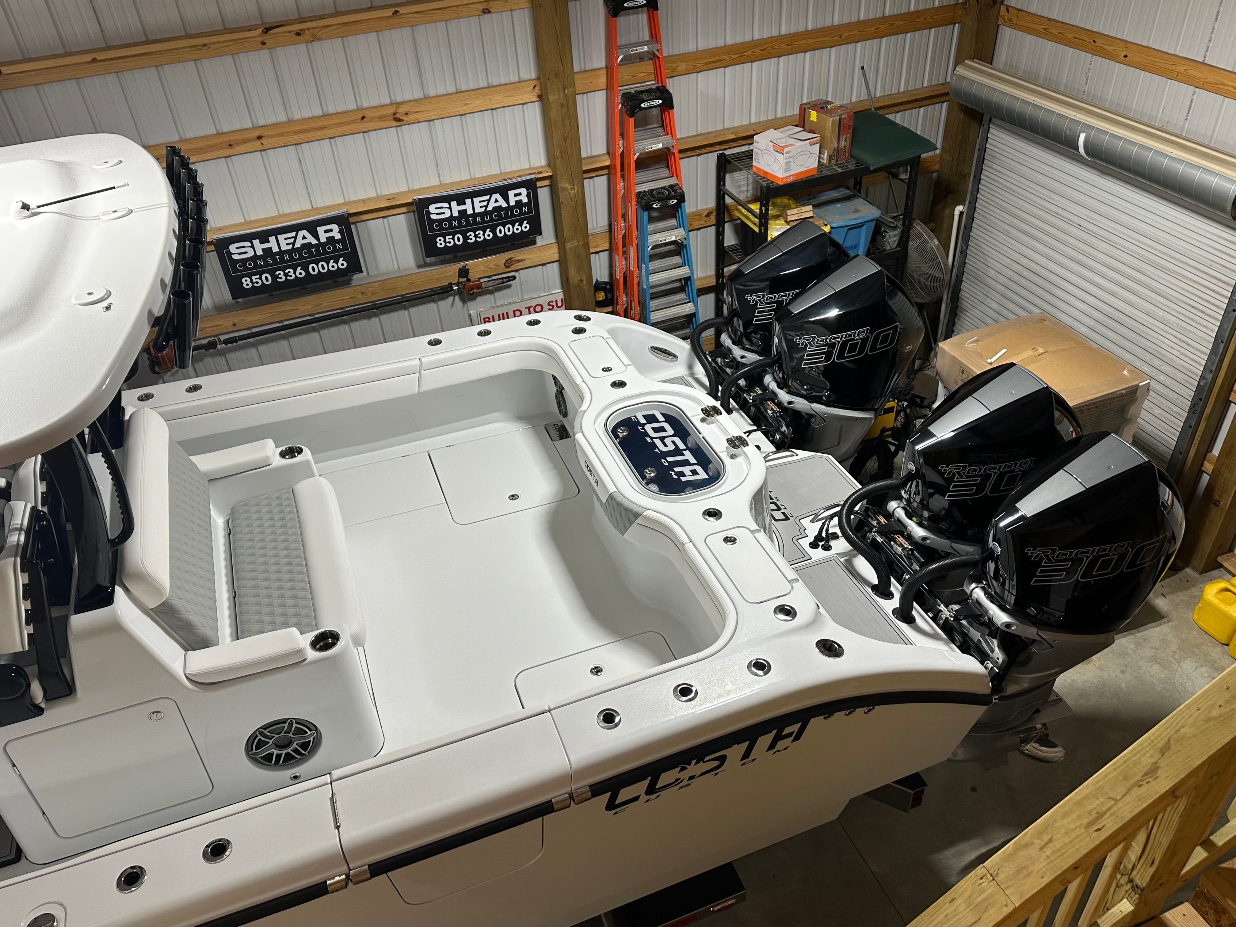 A 2024 Costa Custom Boats 34SV in a storage facility with three outboard motors.