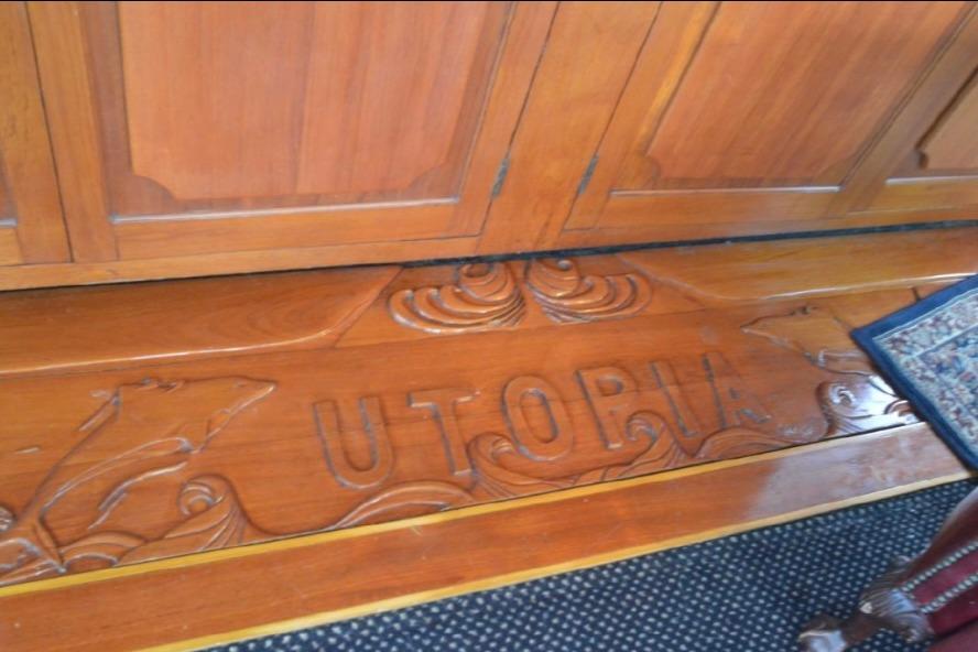 Wooden interior detail of 1974 Pacemaker Cockpit Motoryacht with carved "UTOPIA" design.