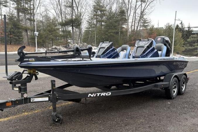 2026 Nitro Z20 XL boat on trailer, parked outdoors in wooded area.