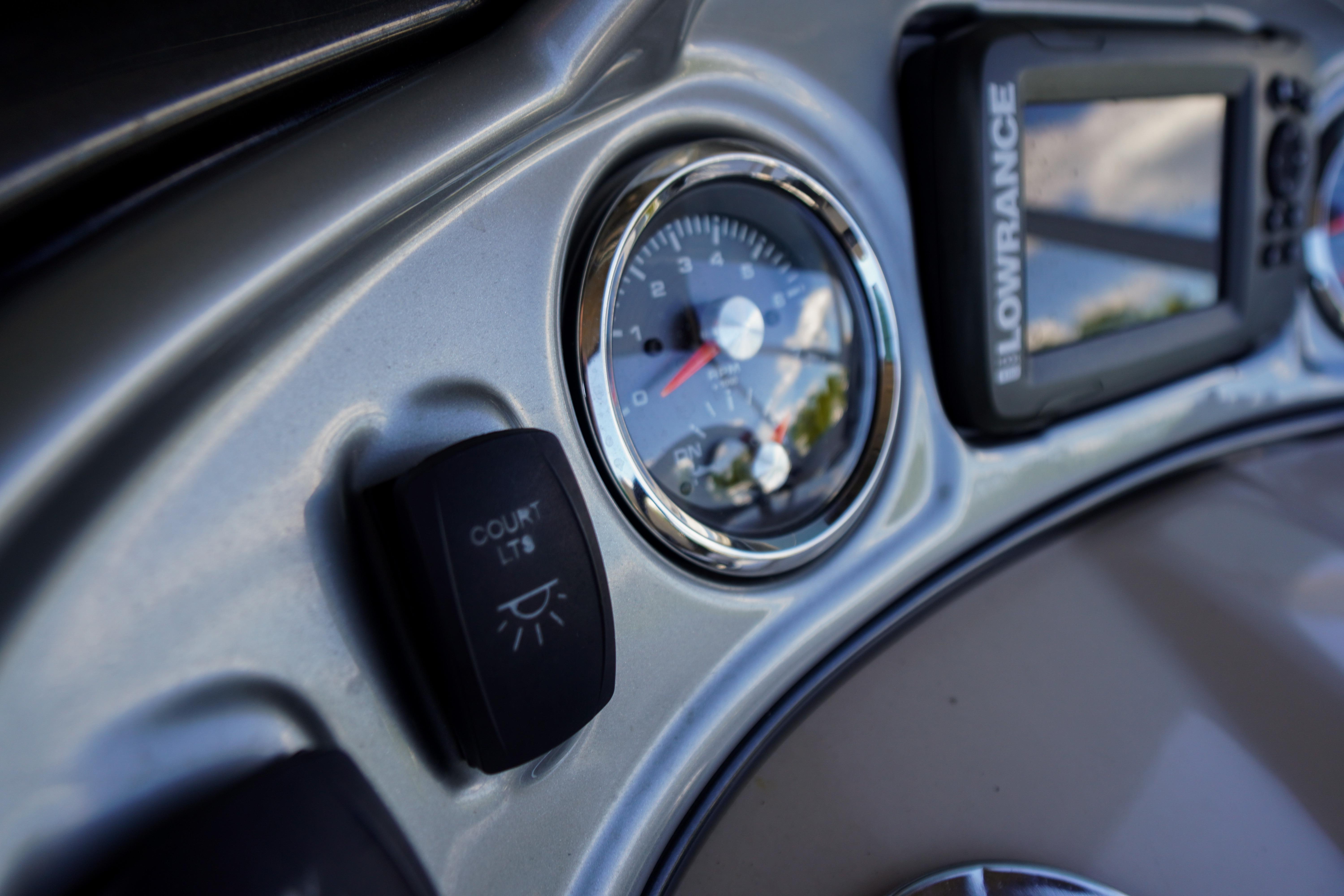 Dashboard of 2019 SUNTRACKER Fishin' Barge 22 DLX with gauge and Lowrance display.