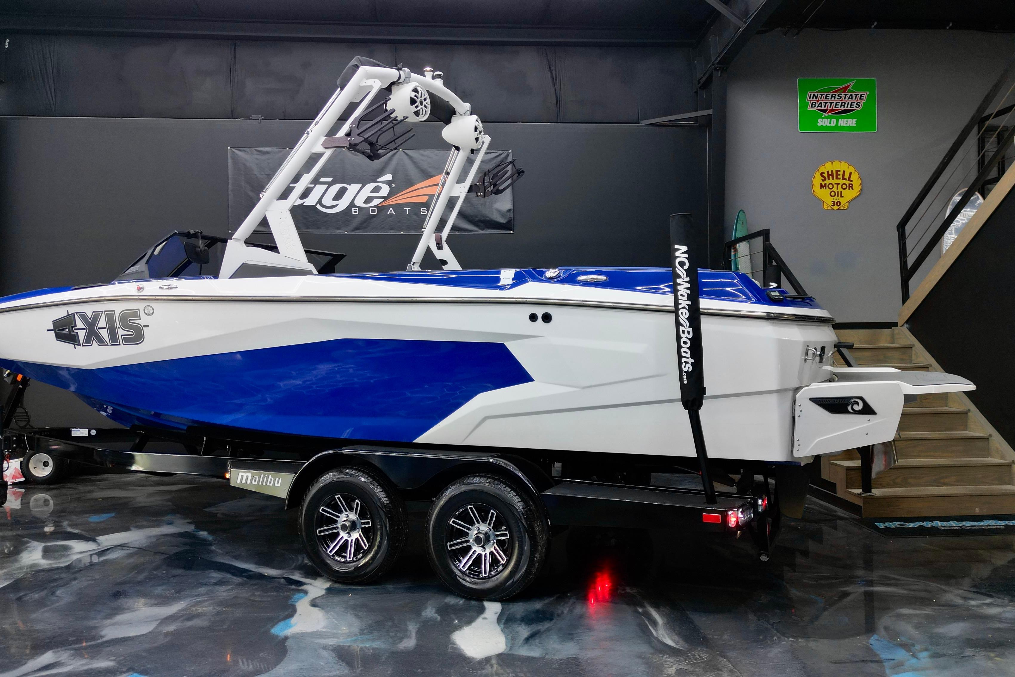 2023 Axis A225 boat in showroom, blue and white design, on trailer.