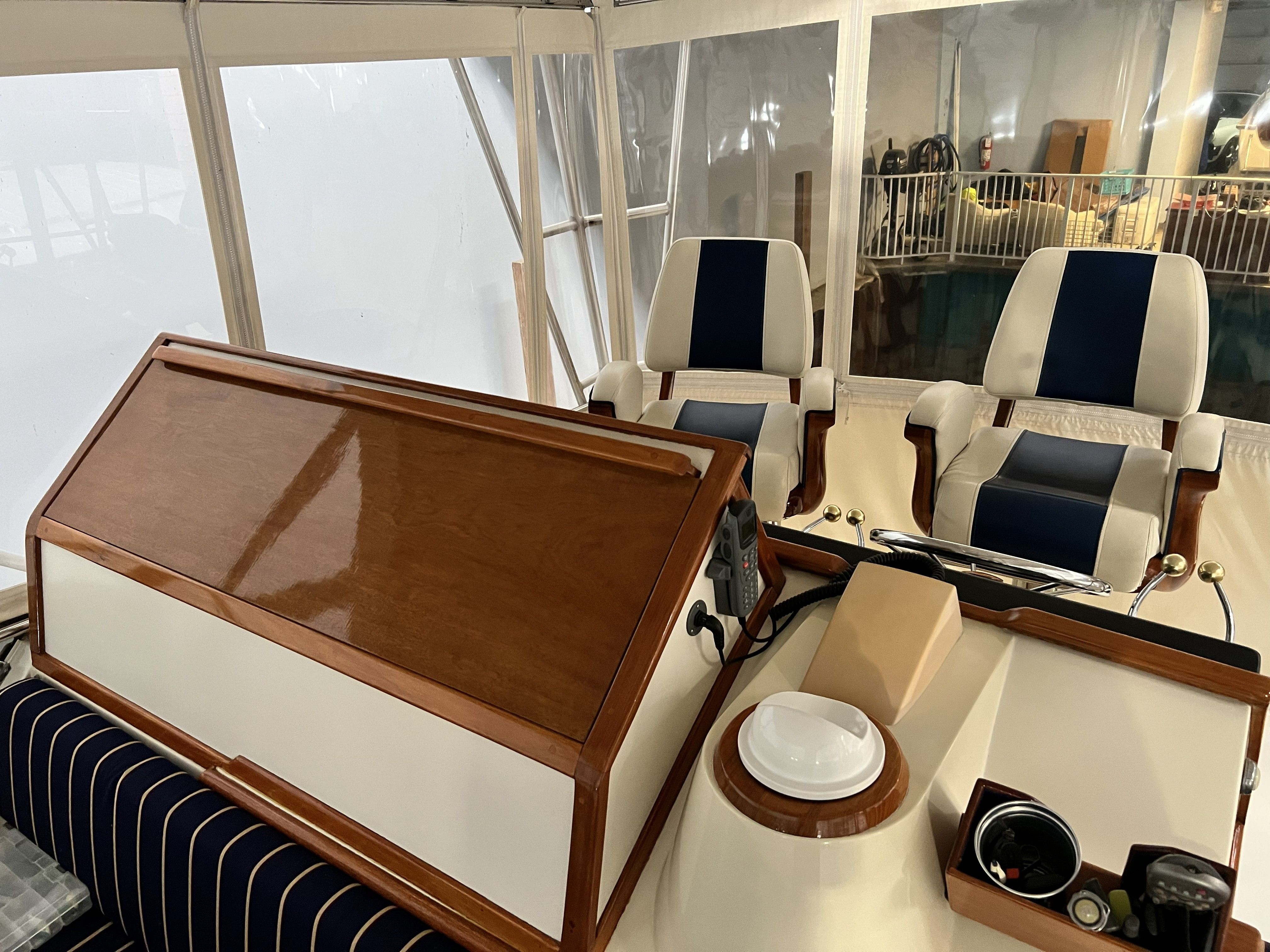Interior view of a 1979 Chris-Craft 45 TF with two cushioned seats and a wooden table.