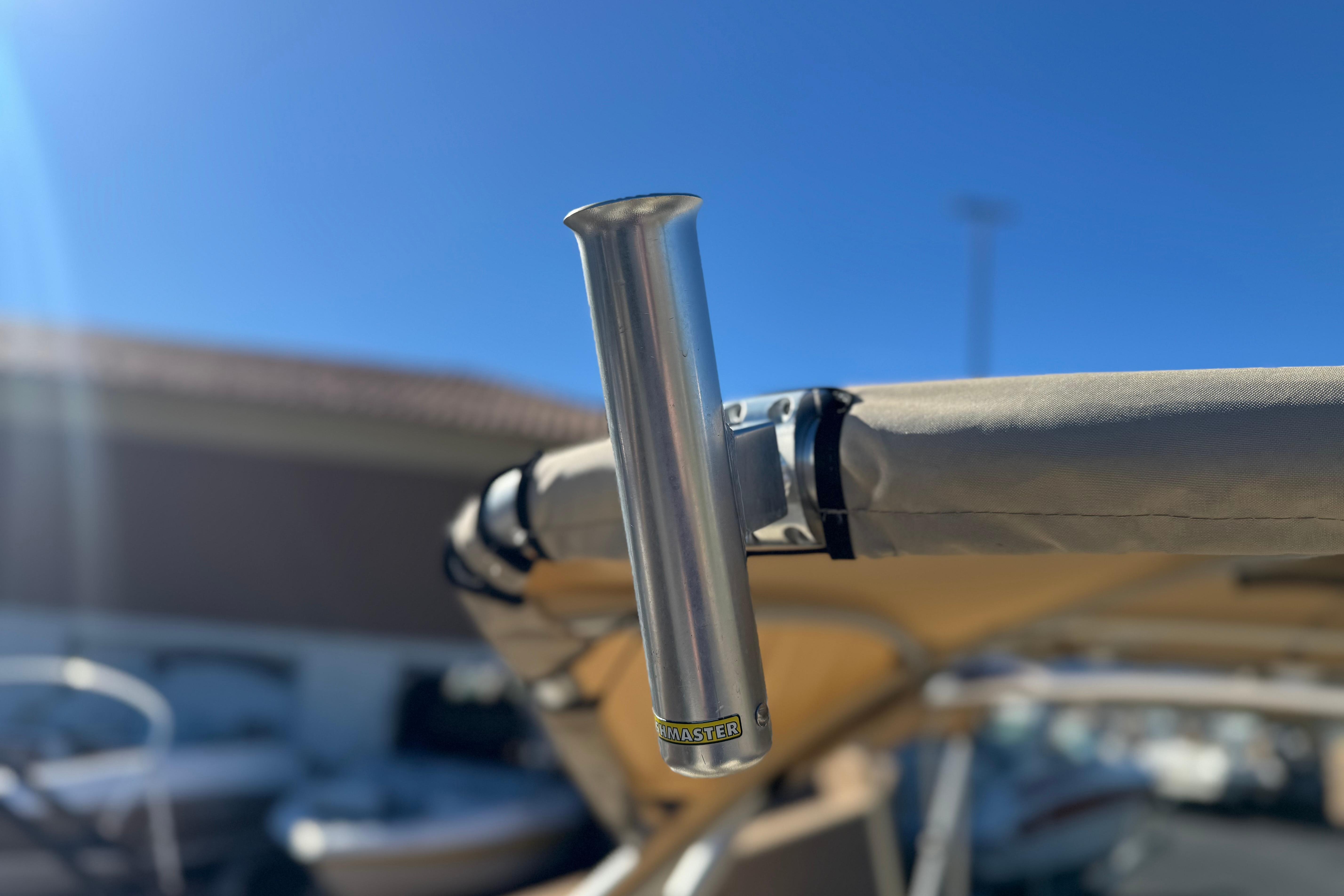 2013 Bennington 2575QCW I/O boat with a metal rod holder under a clear blue sky.