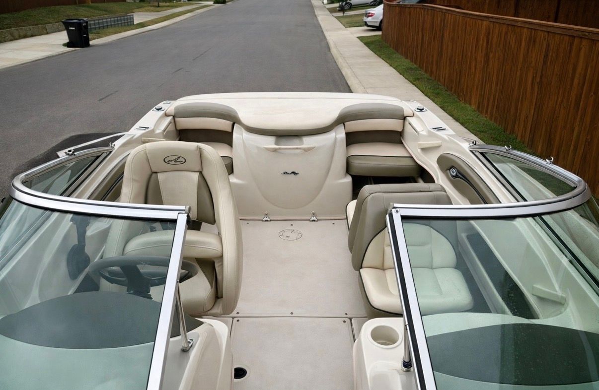 Interior of a 2005 Sea Ray 200 Sport boat, beige upholstery.