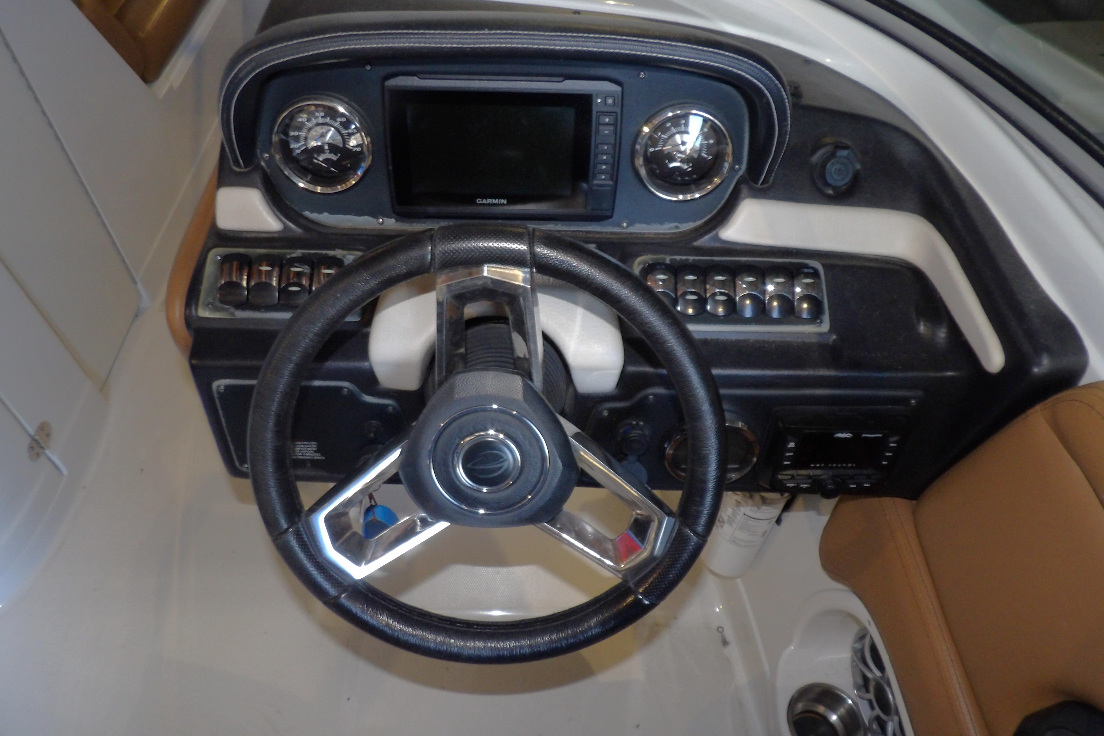 2023 Crownline 250 XSS boat dashboard with steering wheel and control panel.
