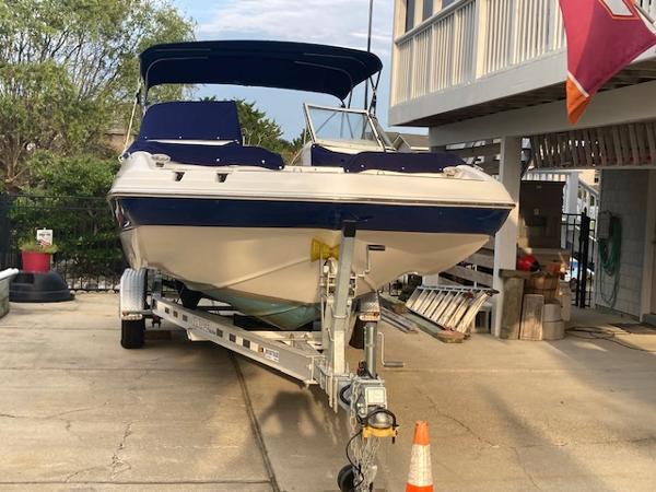 2006 Hurricane SunDeck 237 OB boat on trailer in driveway.