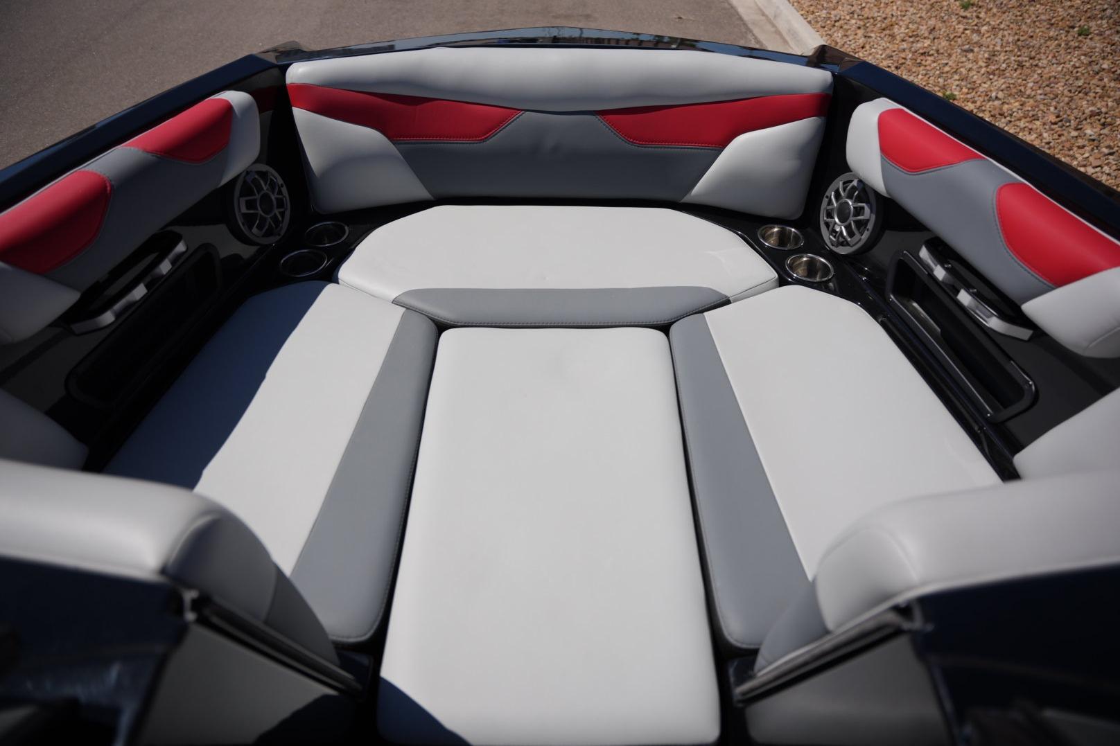 2019 Axis A22 boat interior with gray and red cushioned seating and built-in speakers.