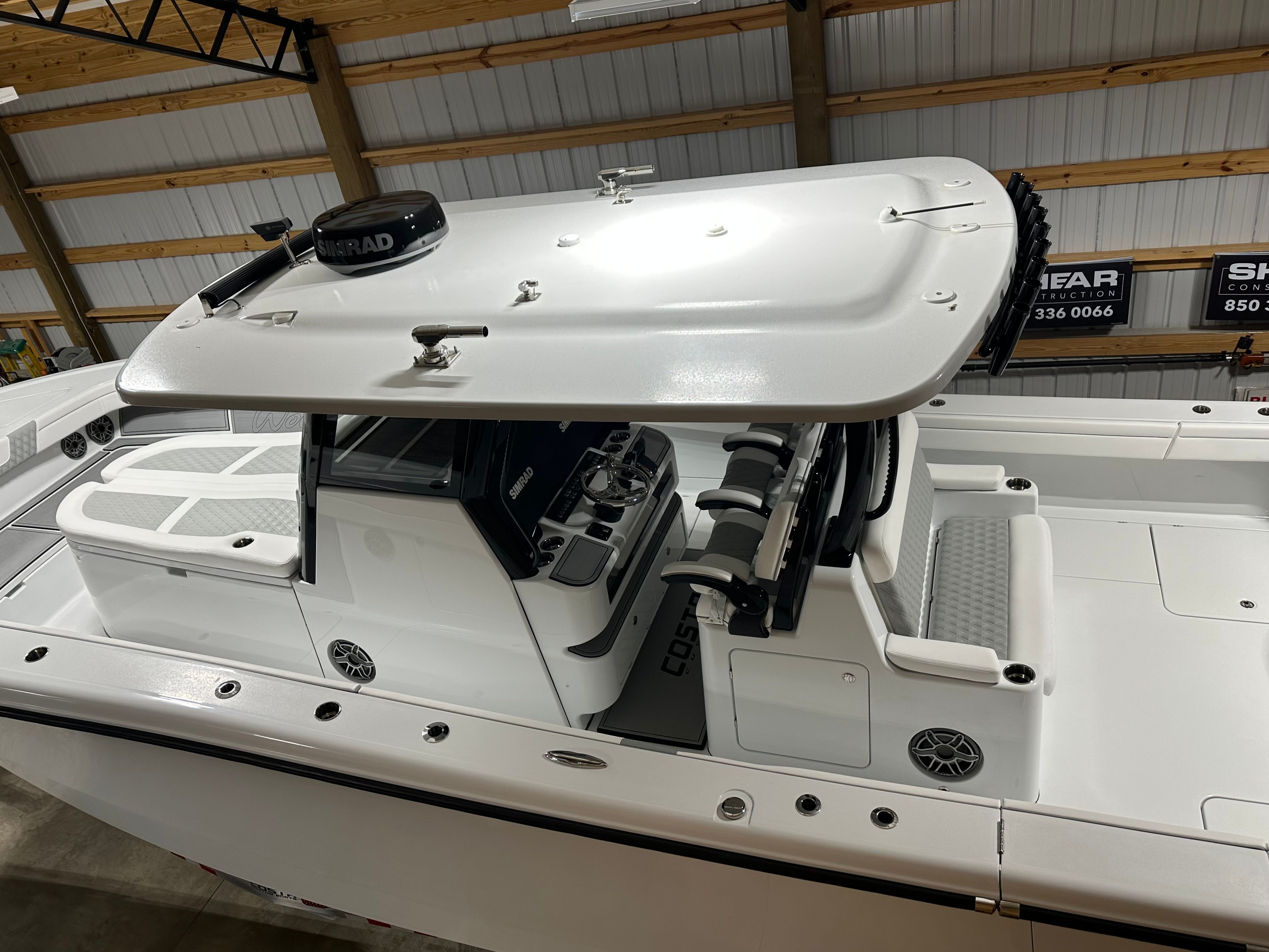 A modern boat with a spacious deck and a covered helm station.