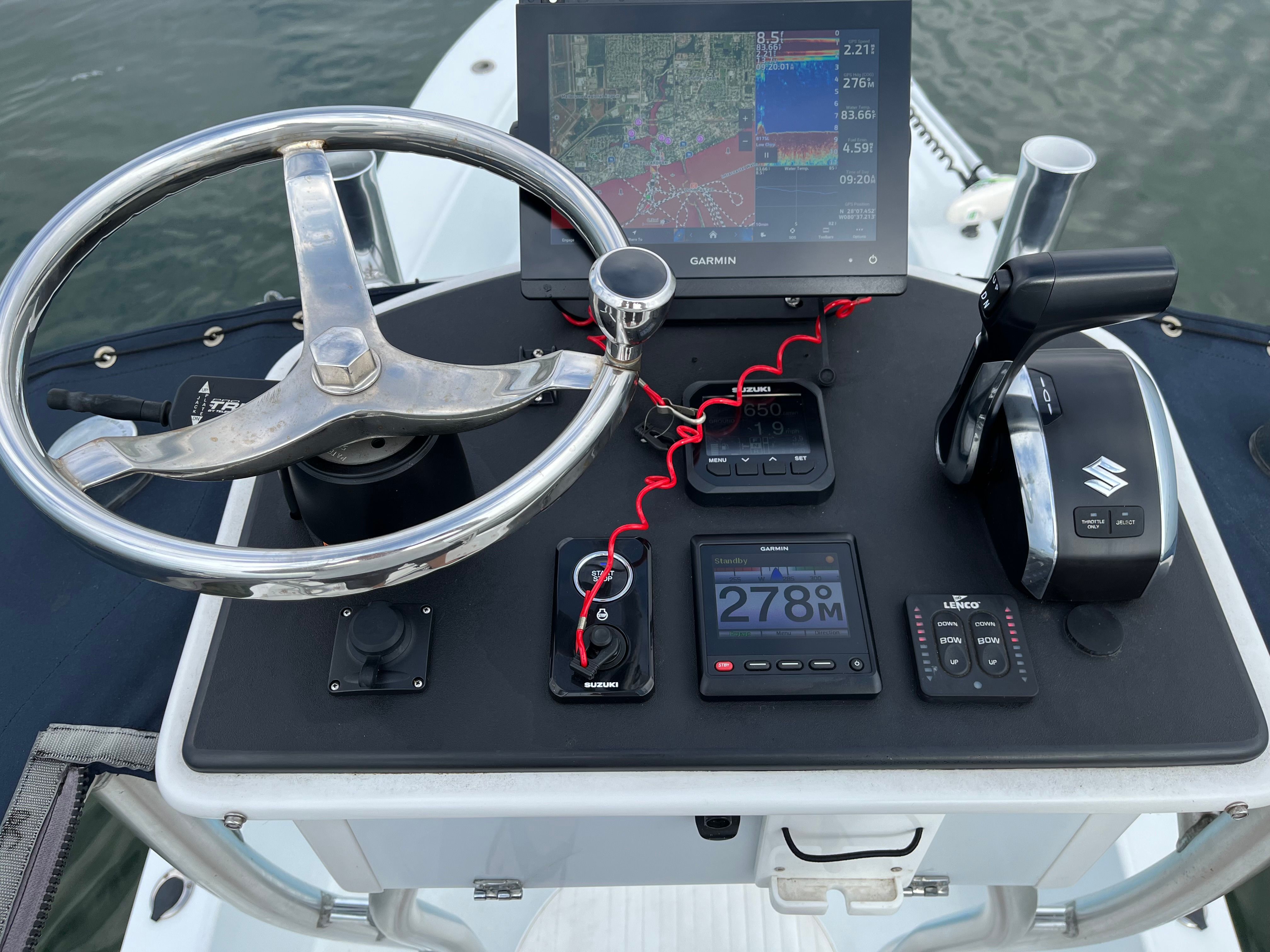 The image shows a boat's helm with a Garmin navigation system and various controls.