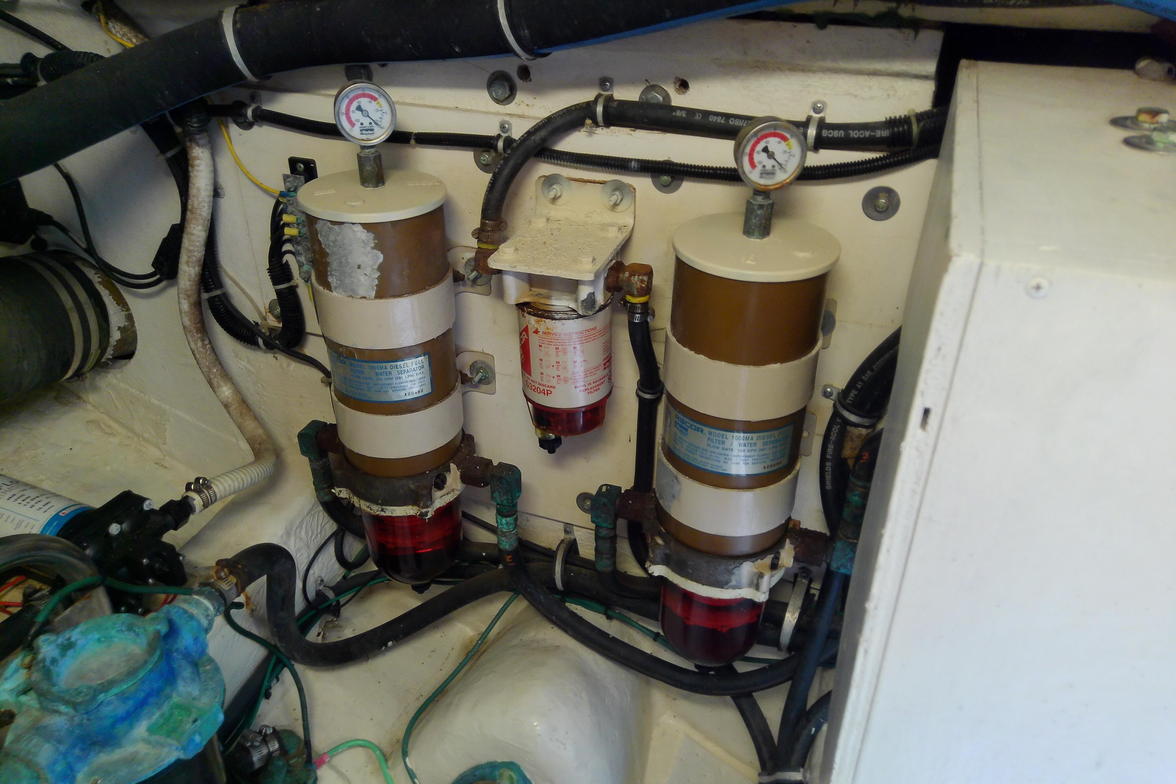 Engine room of 2000 Tiara Yachts 4100 Open, featuring fuel filters and gauges.
