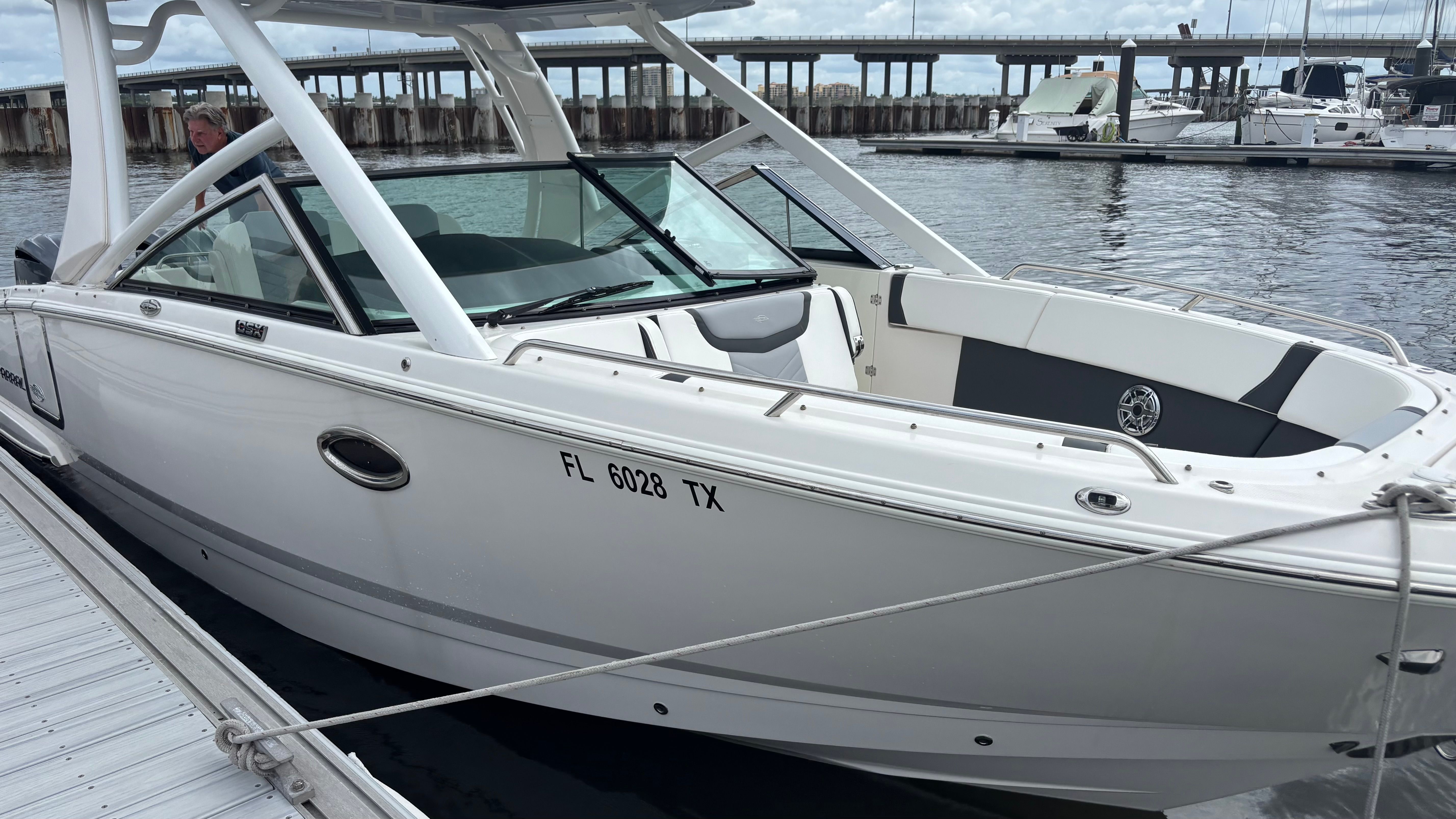 A 2023 Chaparral 28 OSX boat docked. It features a sleek design and white color.