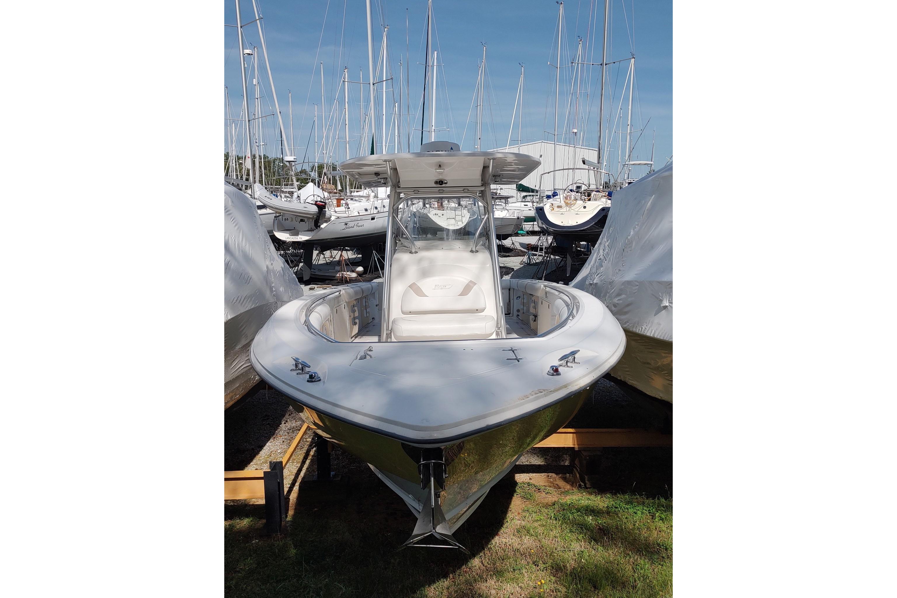2006 Boston Whaler 320 Outrage boat docked among other vessels in a marina.