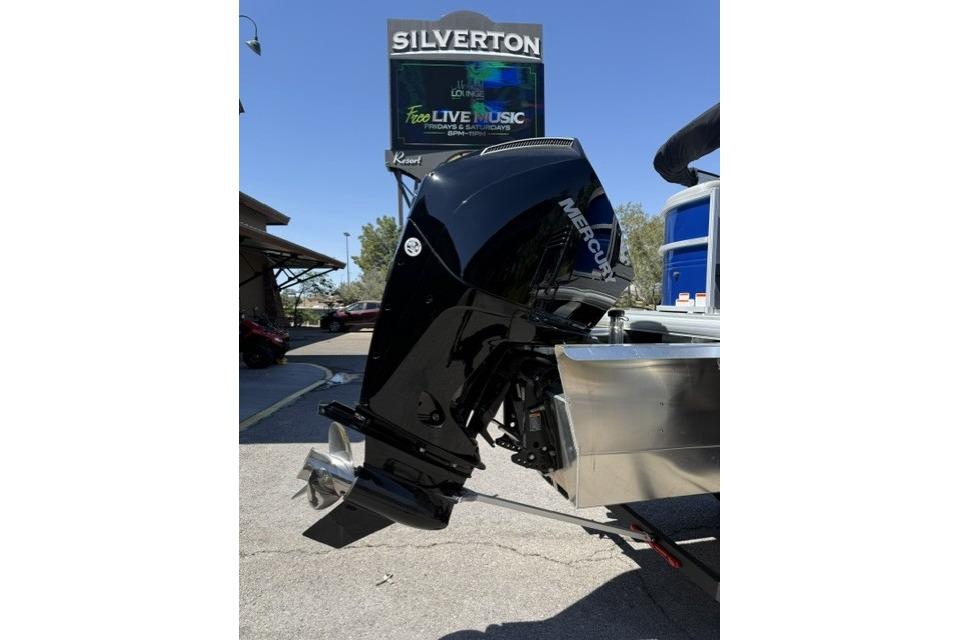 2026 Sun Tracker Party Barge 24 XP3 with Mercury outboard motor, parked near Silverton sign.