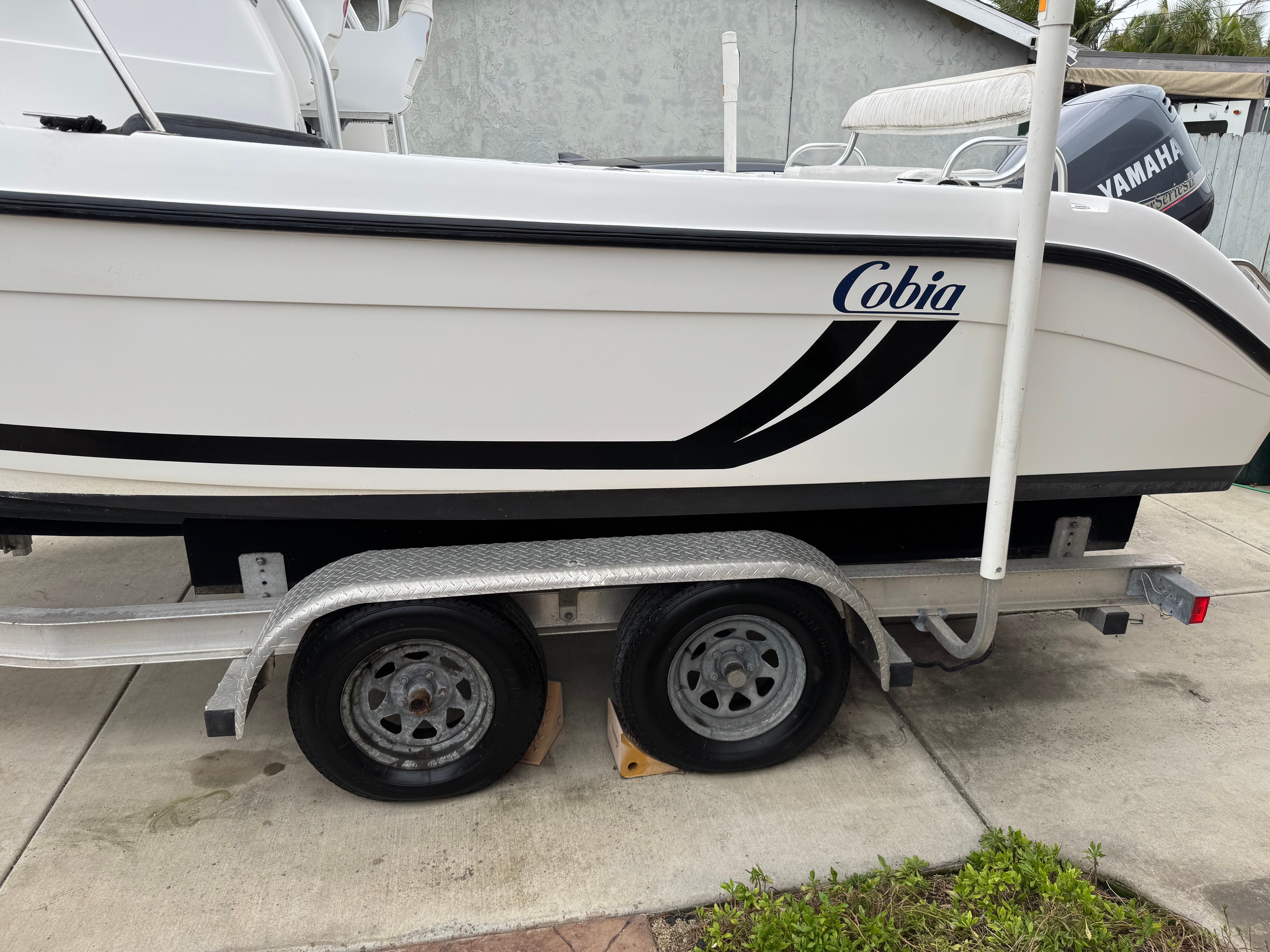 A 1999 Cobia Walkaround boat on a trailer, with a Yamaha motor in the background.