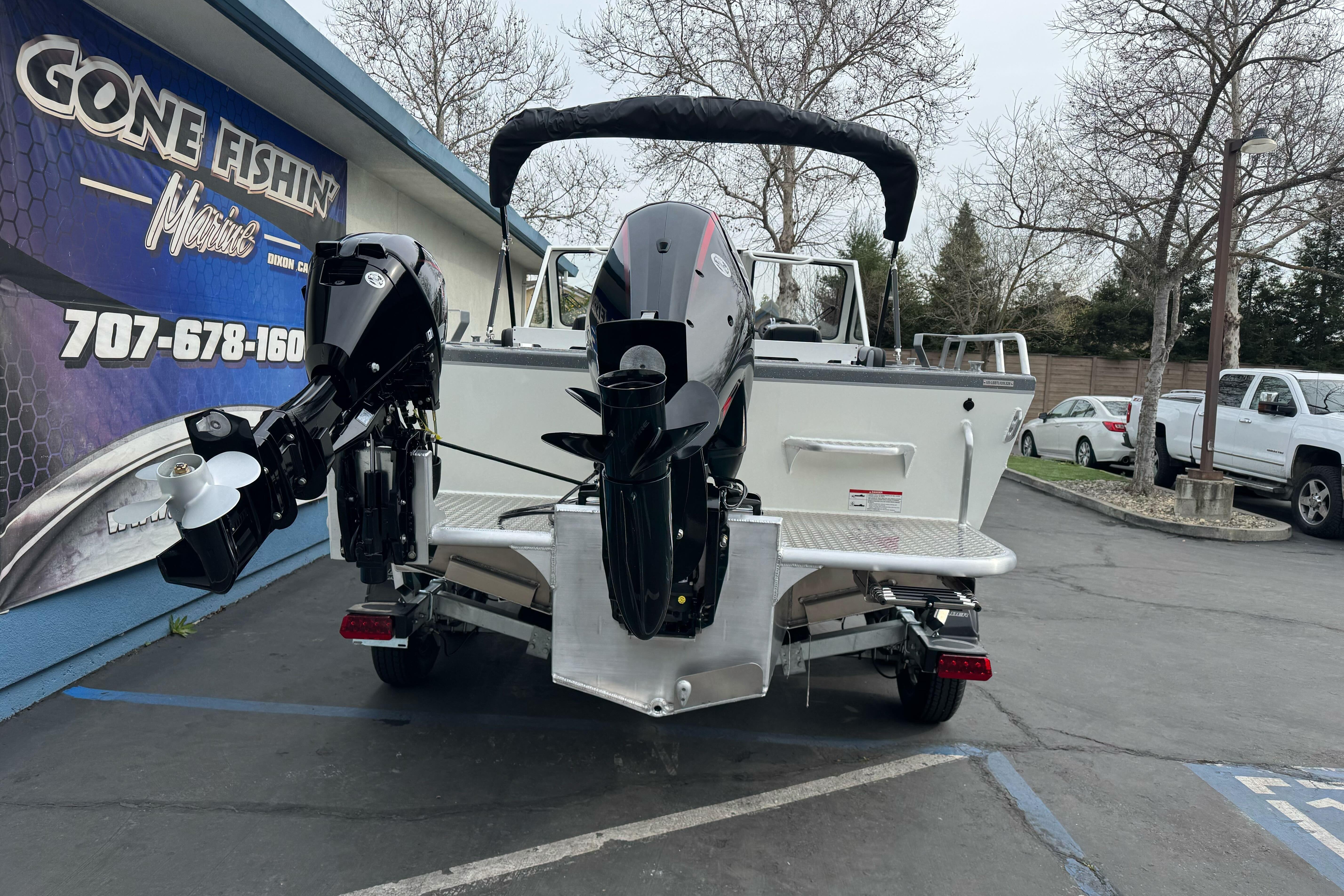 2026 Lund 185 Heavy Gauge boat with dual outboard motors at a dealership.