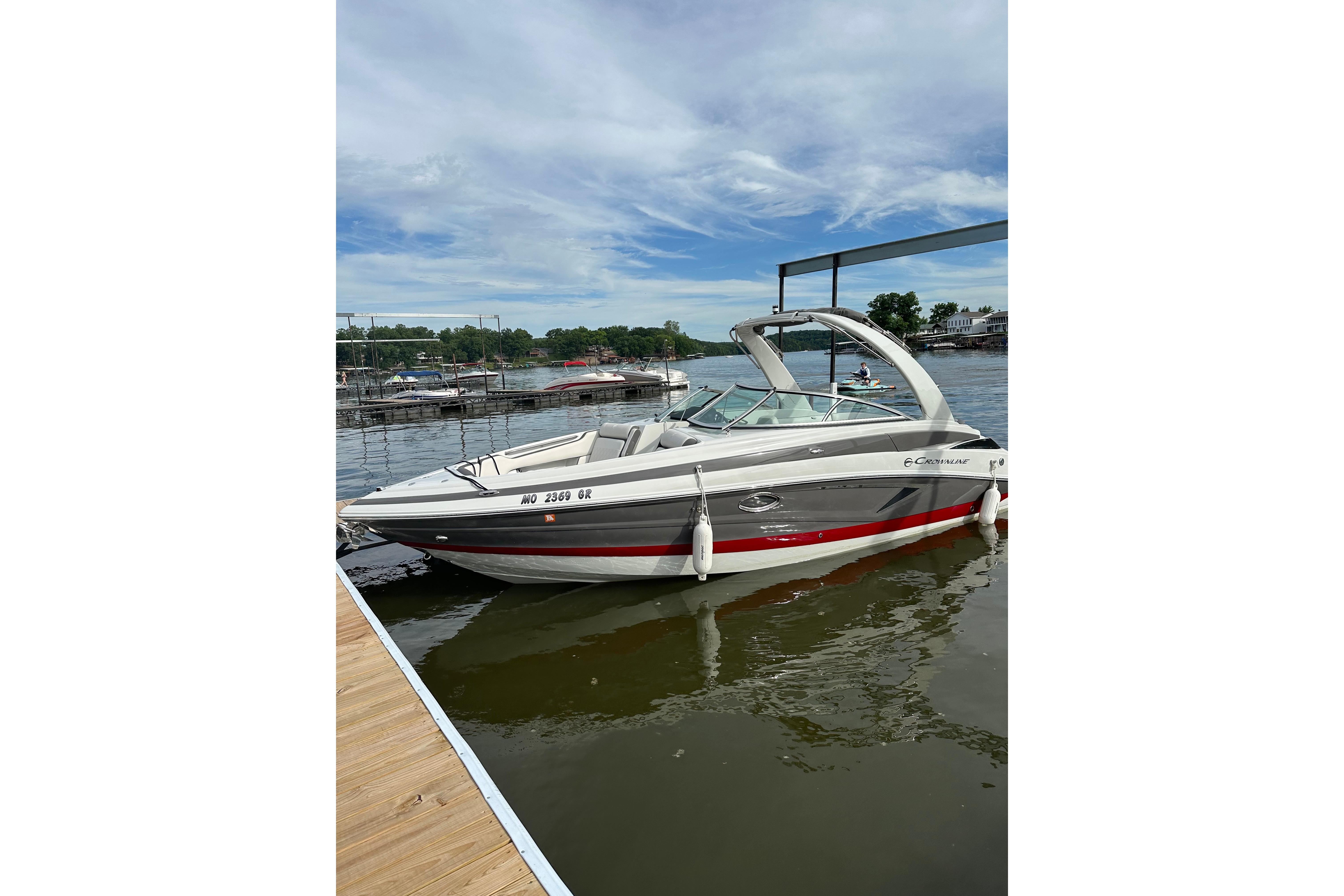 2022 Crownline 265 SS boat docked on a calm lake under a clear sky.