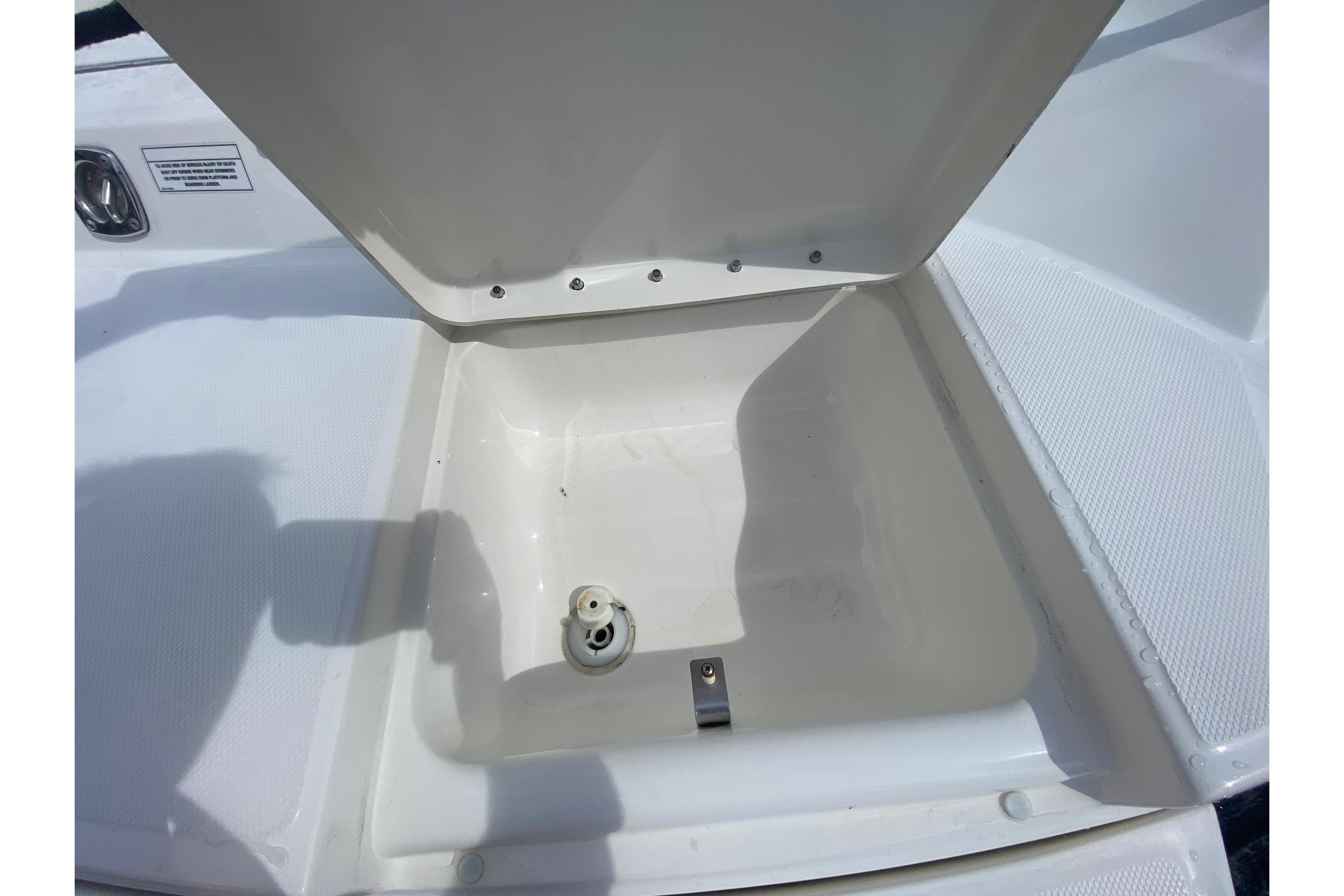 Open storage compartment on 2010 Sea Ray 300 SLX boat deck.