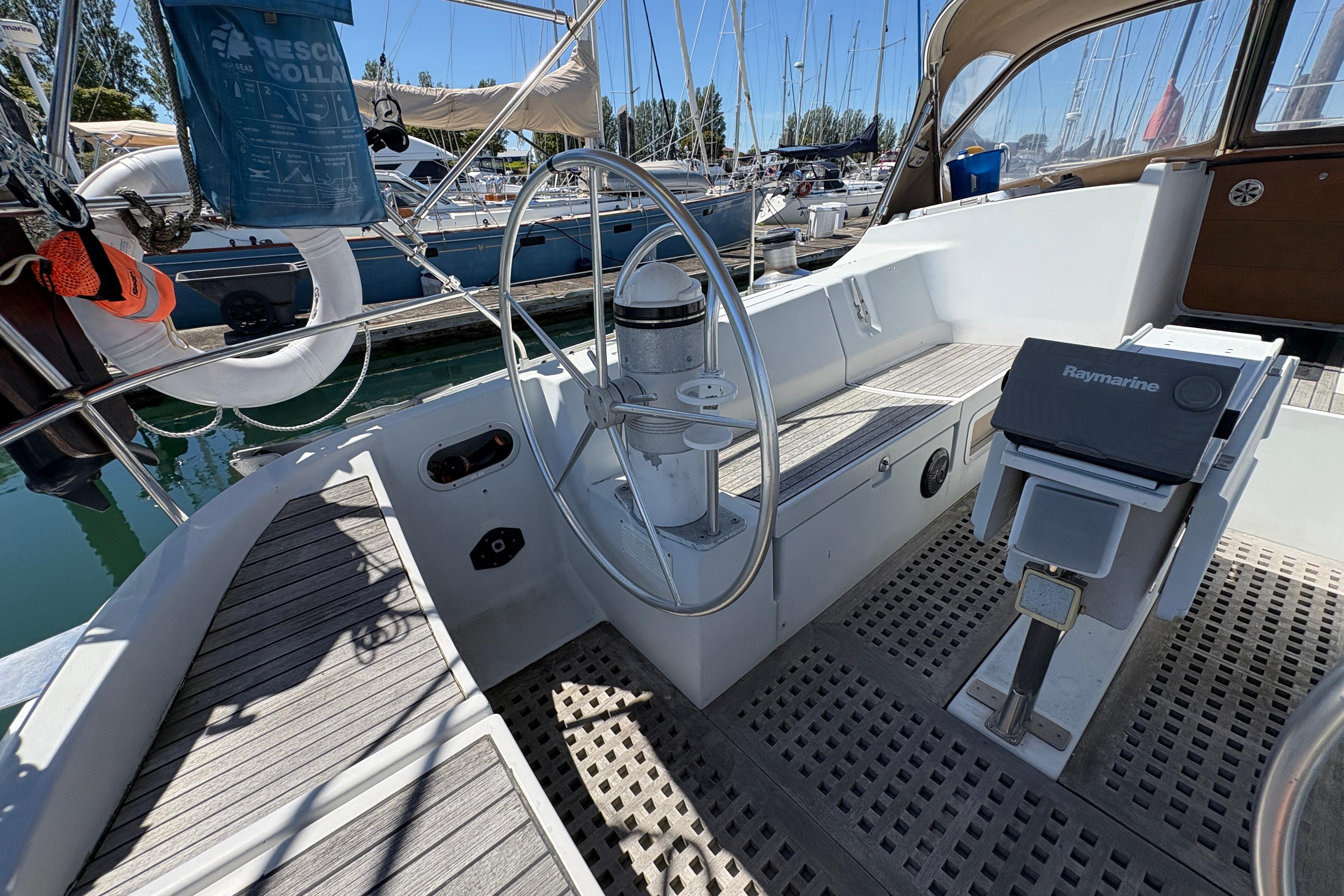 Cockpit of 1990 Beneteau Oceanis 500 sailboat with steering wheel and navigation equipment.