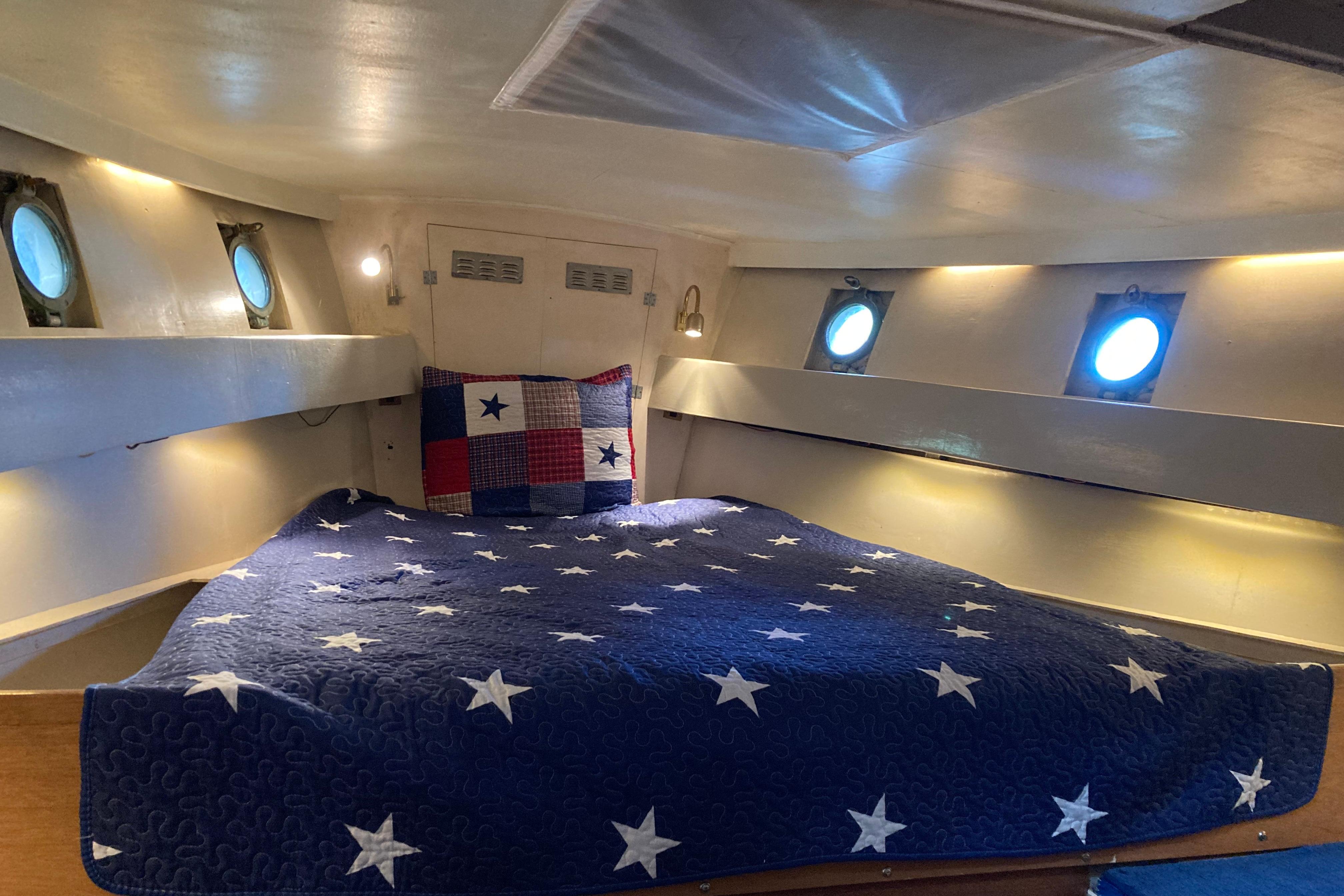 Cozy cabin interior of 1942 Grenfell 42 Custom boat with star-patterned bedding.