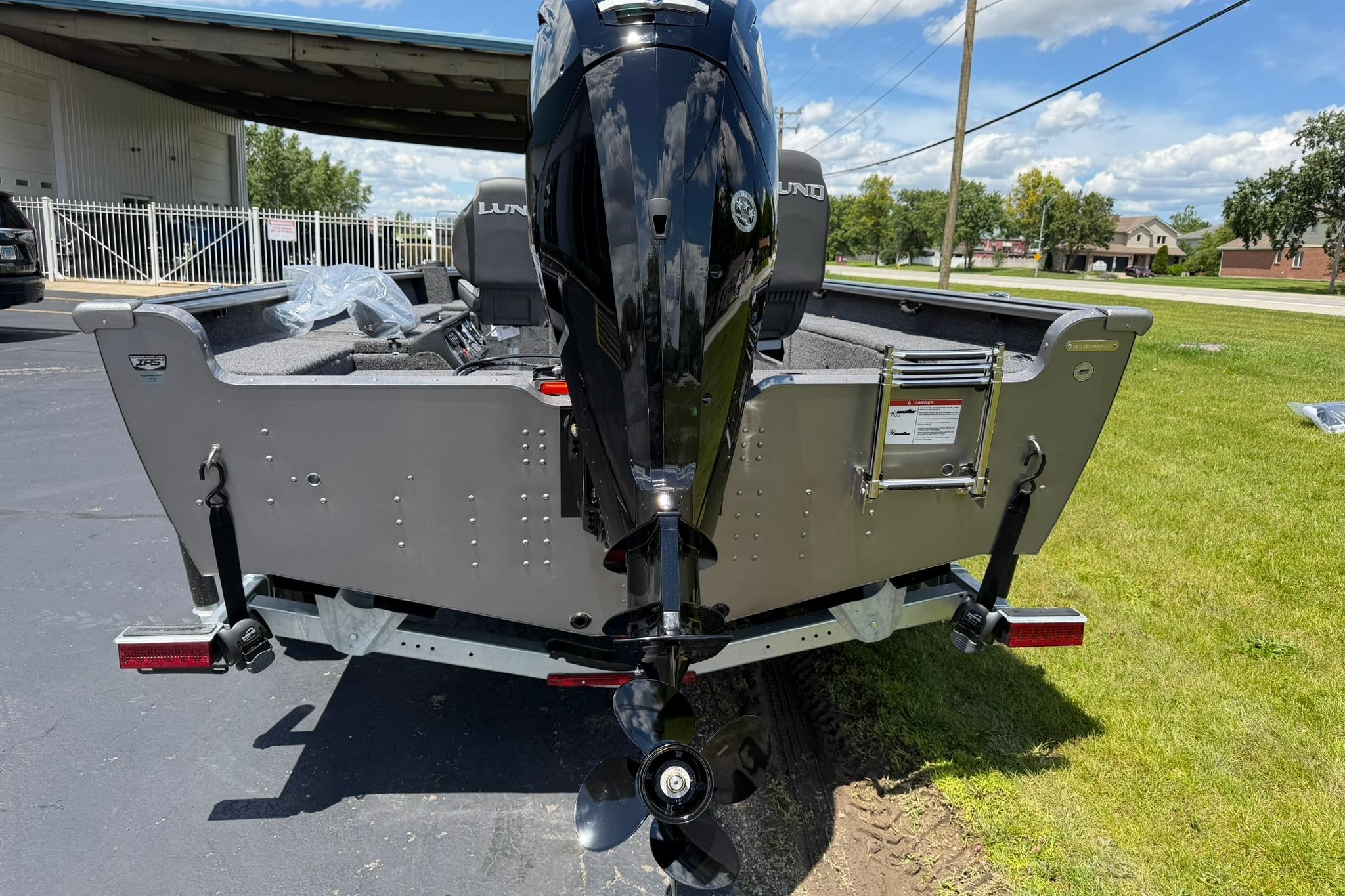 2027 Lund 1875 Pro Guide boat with powerful outboard motor, parked outdoors on sunny day.