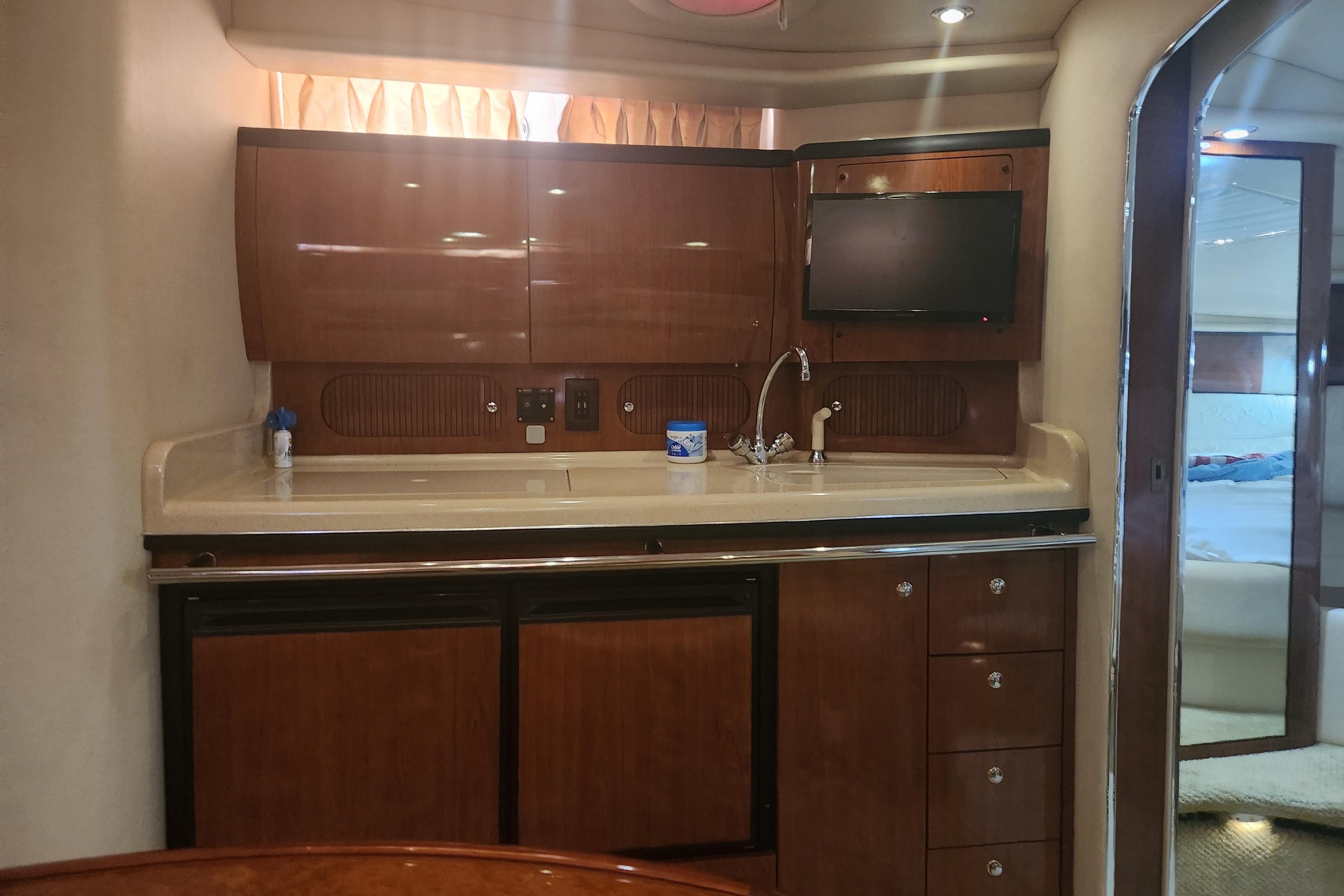 Interior of 2003 Sea Ray 360 Sundancer yacht with kitchenette and TV.